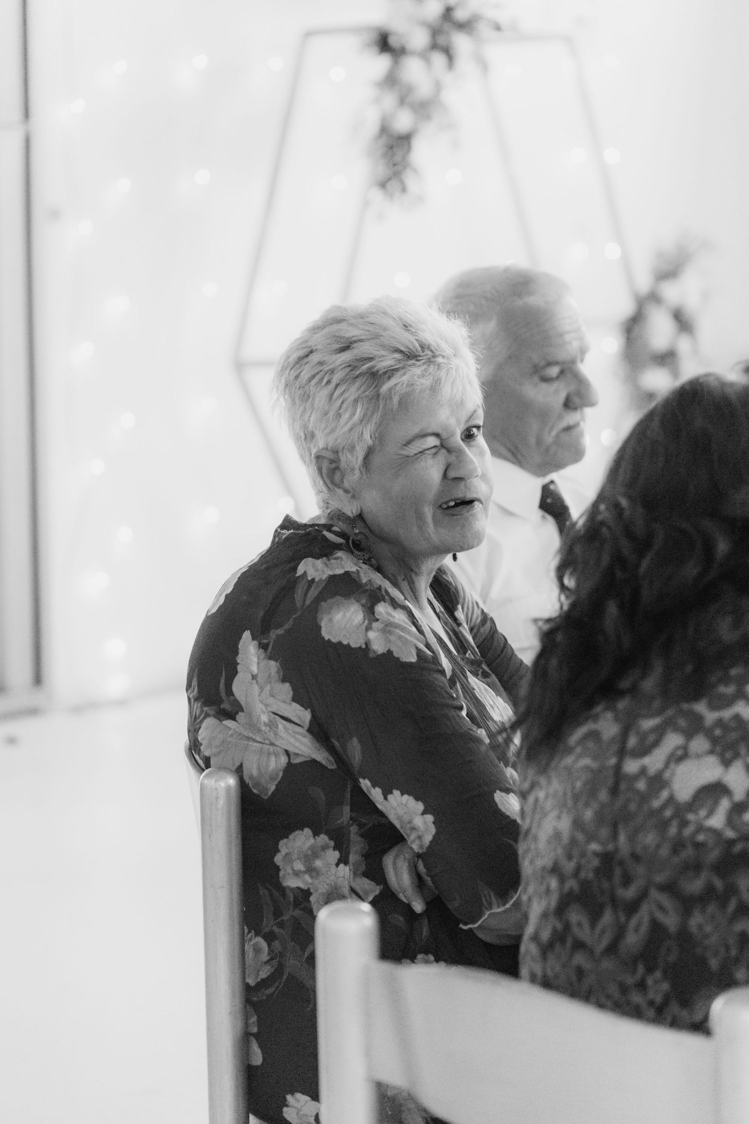 Emotional older woman reacts during a wedding ceremony in black and white photo.