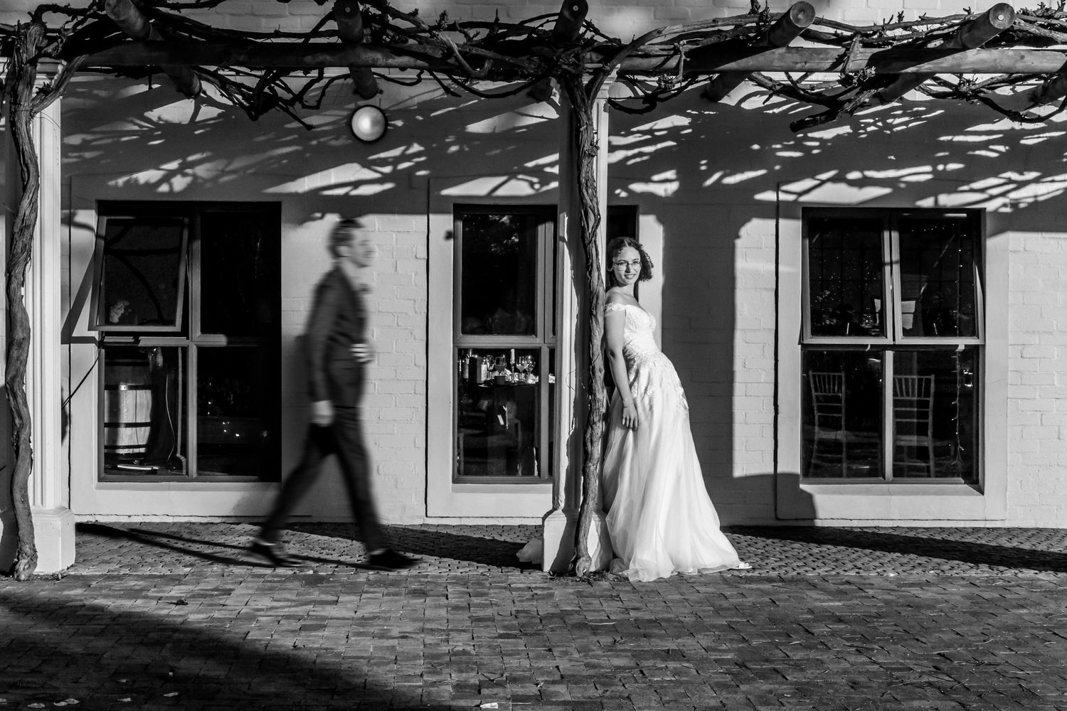 A storyboard sequence of five black and white wedding photographs showing a couple walking outside of a building.