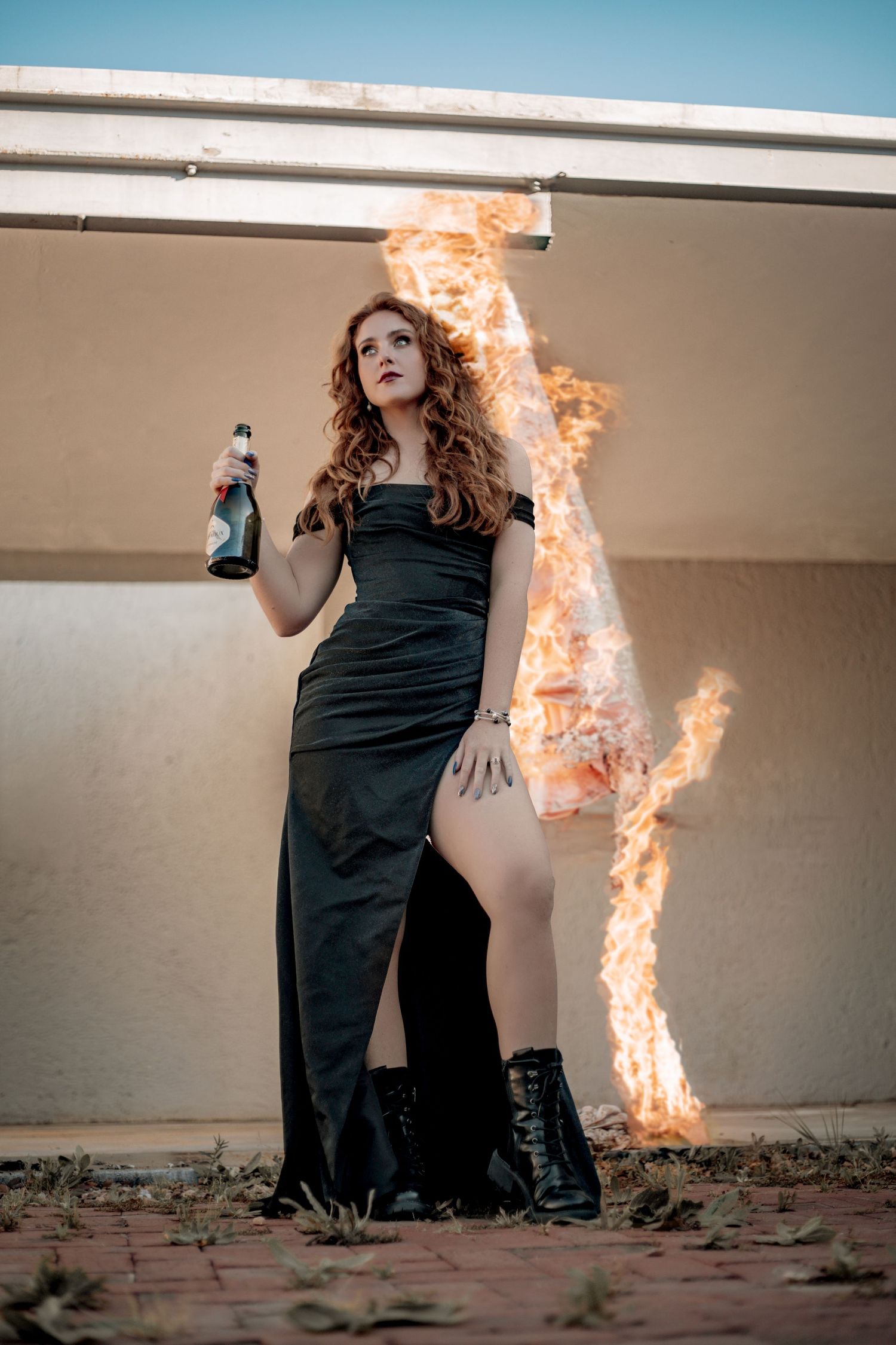 A surreal series of photos showing flames burning dramatically beside a dark-clothed figure against a stark wall.