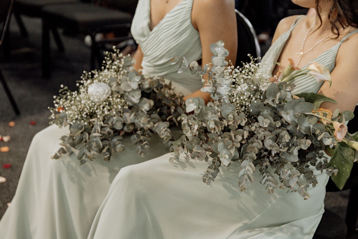 An elegant wedding reception celebration with white florals and table settings in a romantic dimly lit venue.