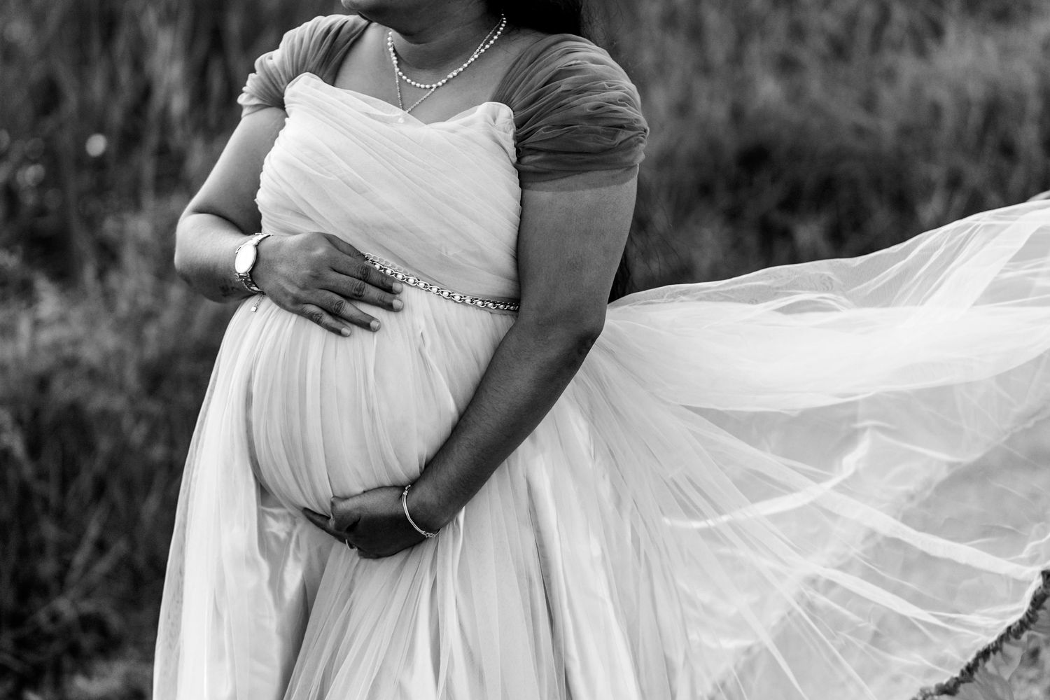 Black and white wedding photos showing romantic moments with bride's dress flowing in the wind.