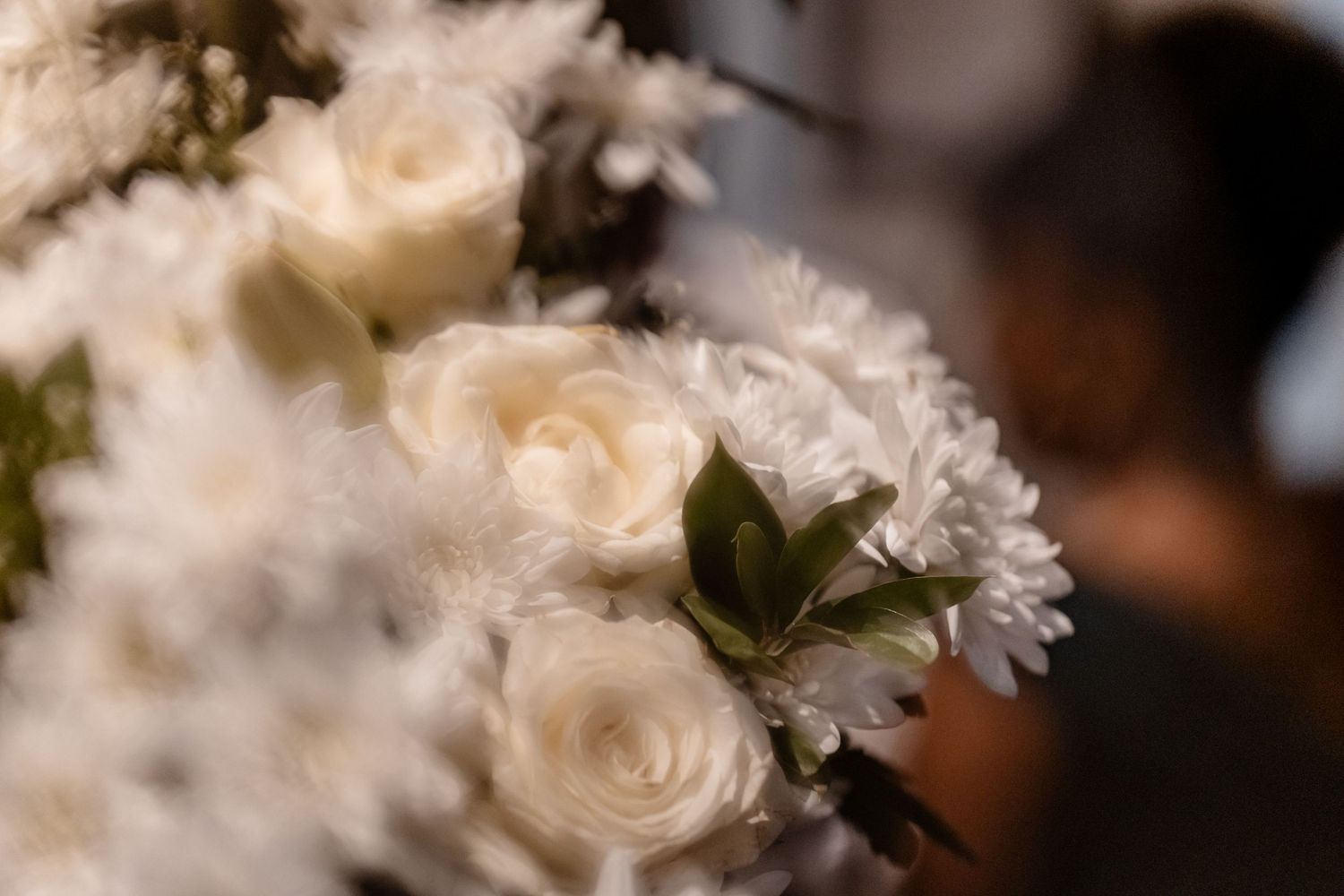 White rose buds and delicate flowers bloom in a soft-focused garden setting creating a dreamy ethereal display.
