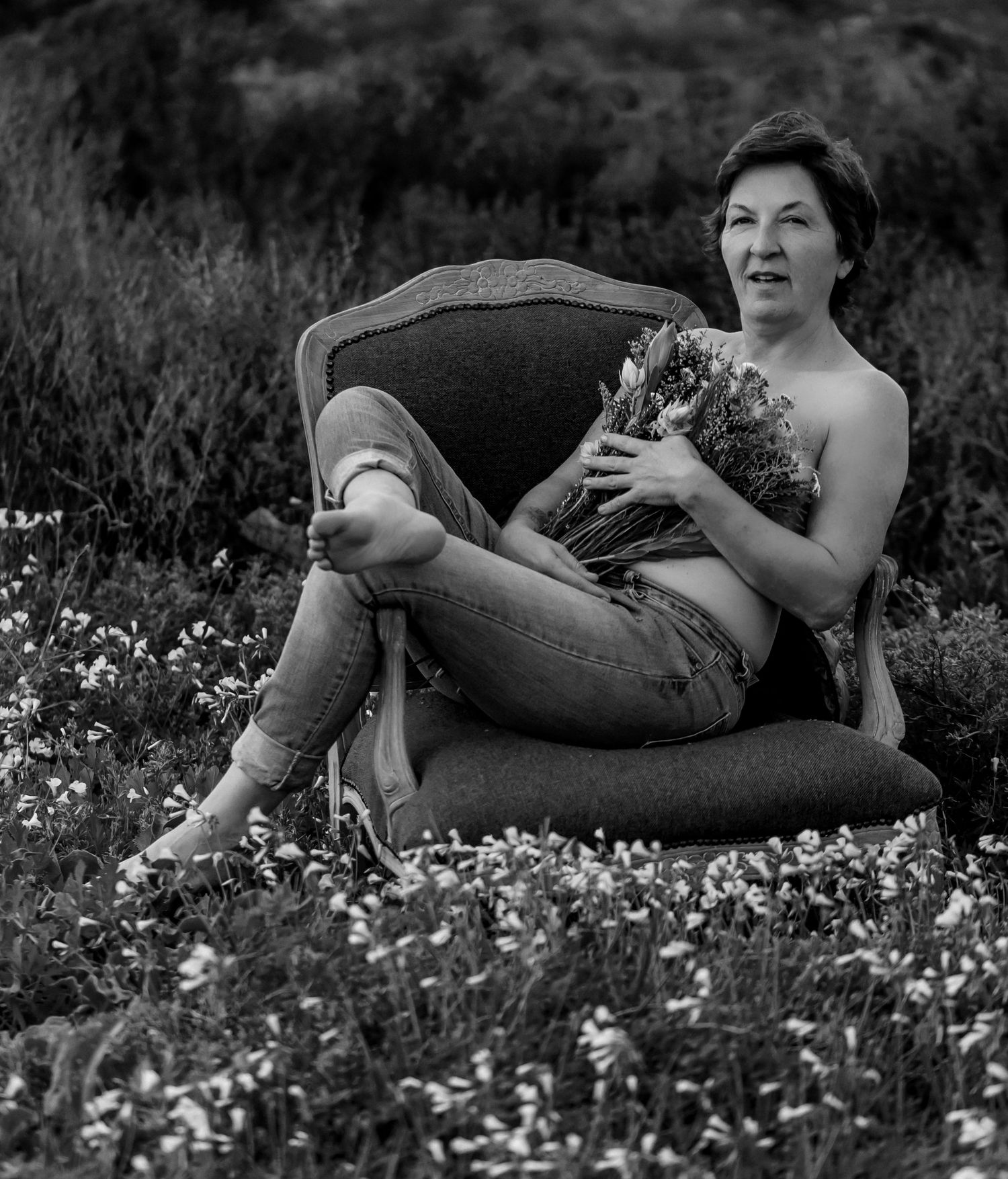 Figure relaxing in a field of white wildflowers captured in black and white from multiple angles.