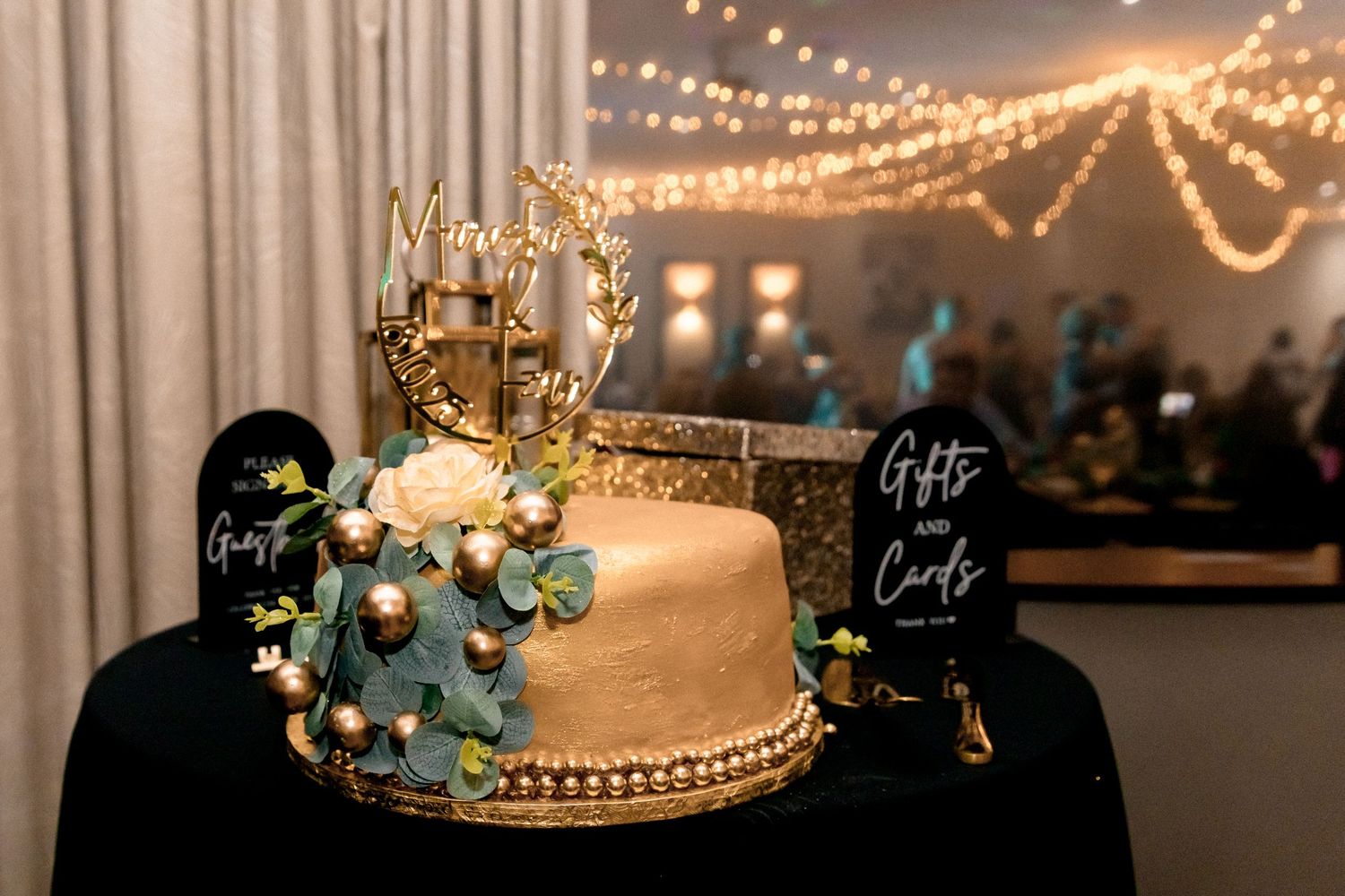 Elegant wedding reception decor with string lights and white drapery creating a romantic ambiance.