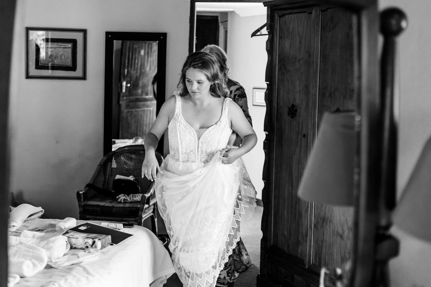 A series of black and white photos show someone working on a bed while wearing white clothing.