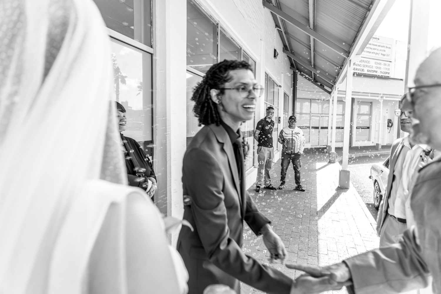 People line up at white tents outdoors during a community event or service station.