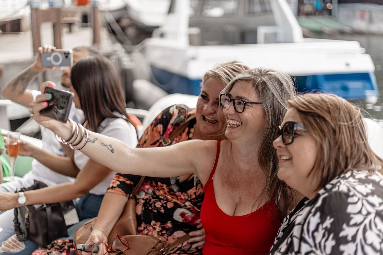 A group of tourists taking selfies and photos while sitting together outdoors during sightseeing.