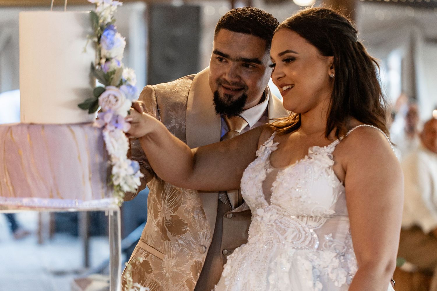 A bride and groom share an intimate moment during their wedding celebration while surrounded by floral decorations.