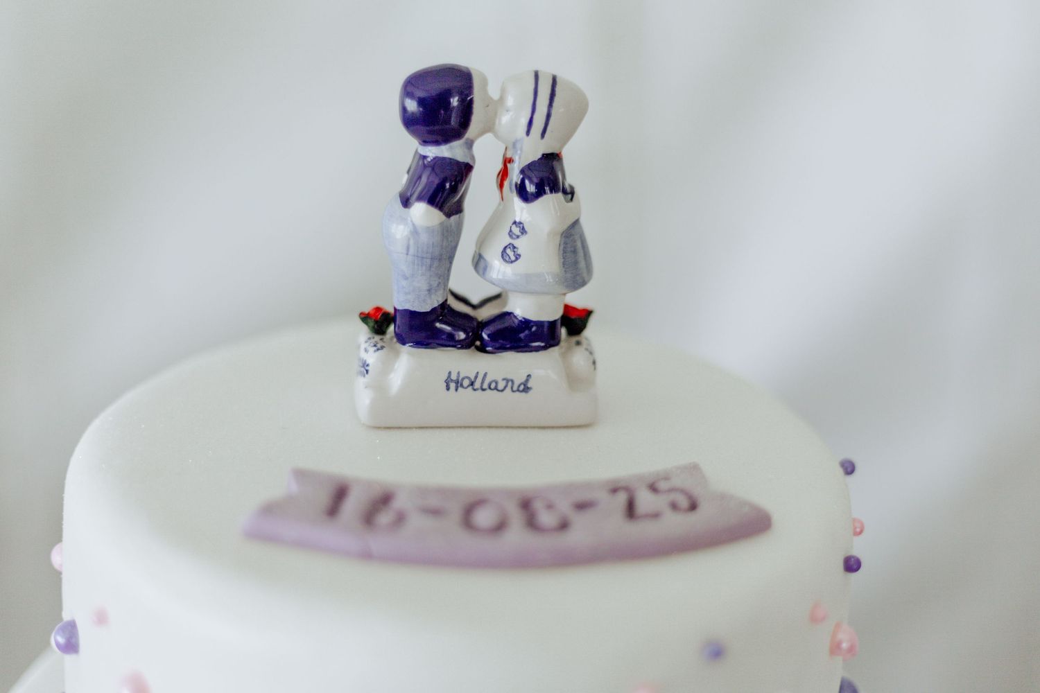 A delicate white ceramic collectible figure is shown with blue accents against a light background.
