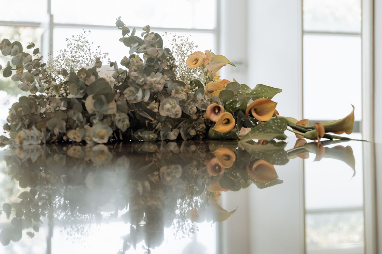 A row of elegant wedding reception tables decorated with white floral centerpieces and glowing candlelight.