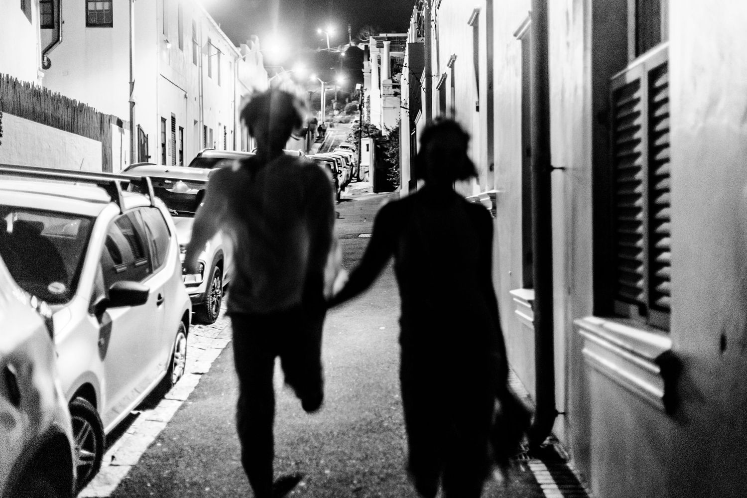 Black and white photo montage showing silhouettes of people walking and running through urban spaces and corridors.