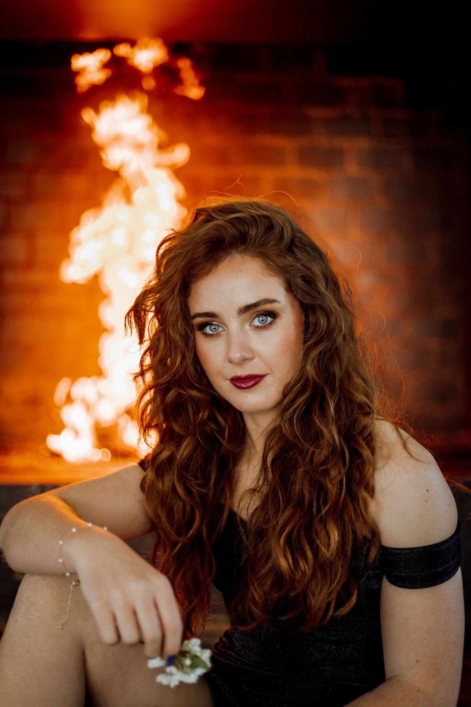A moody photo series with flames in the background creates a dramatic atmosphere for an artistic portrait.