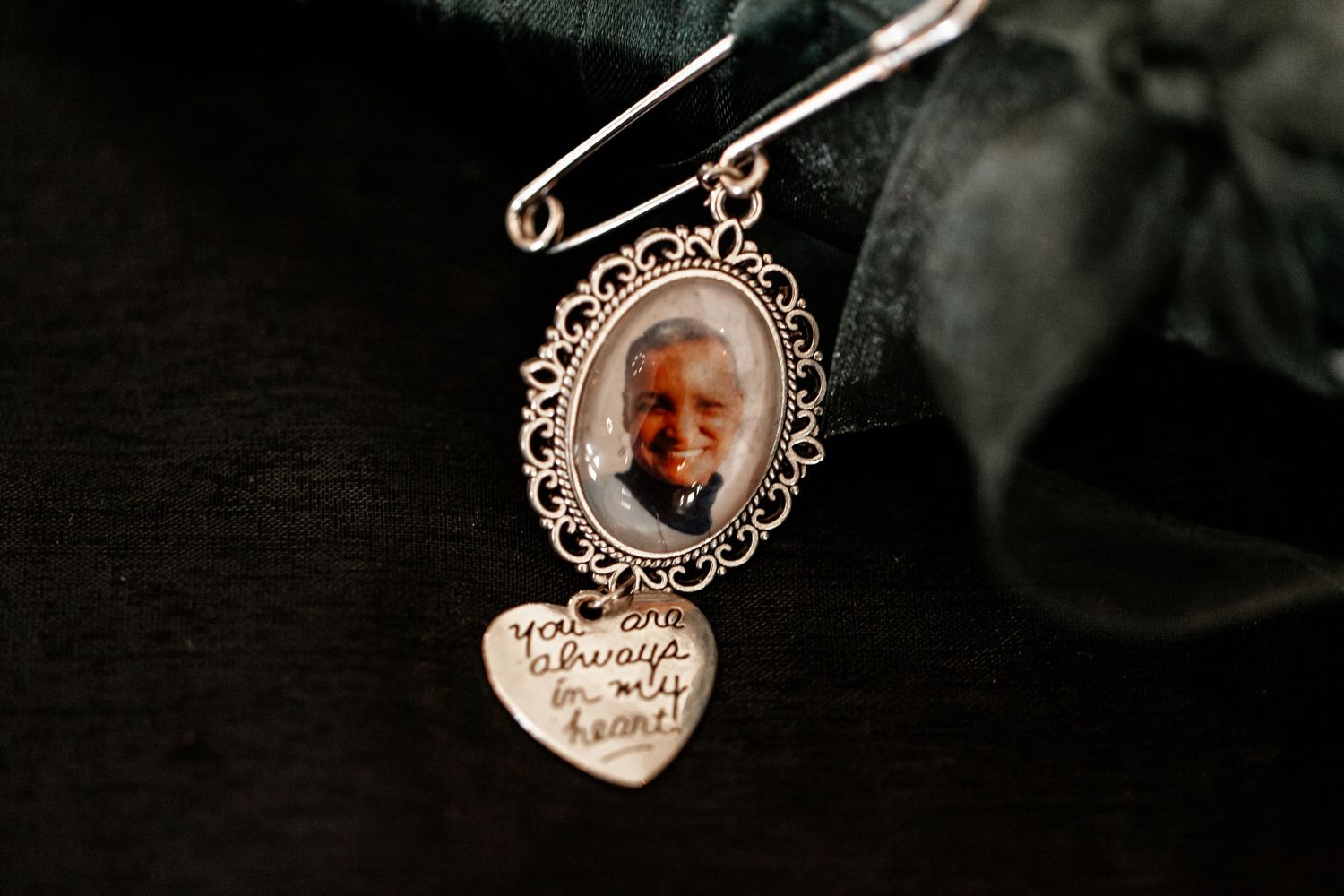A collection of delicate silver and crystal pendants with ornate details displayed against a dark background.