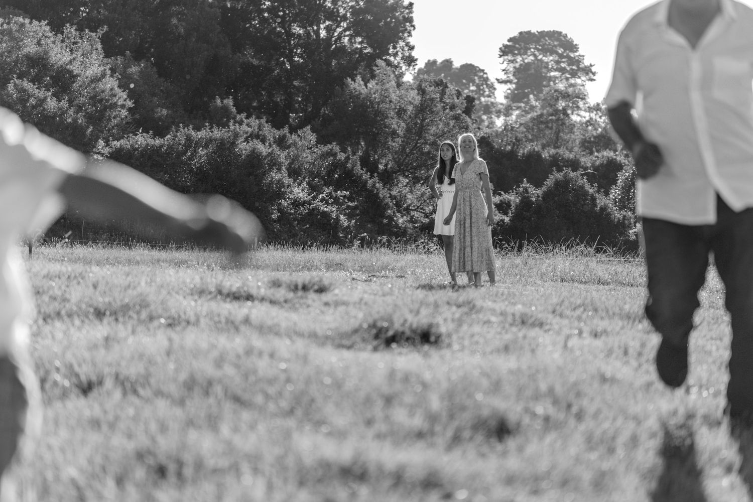 People running and playing on a grassy field during an outdoor recreational activity.