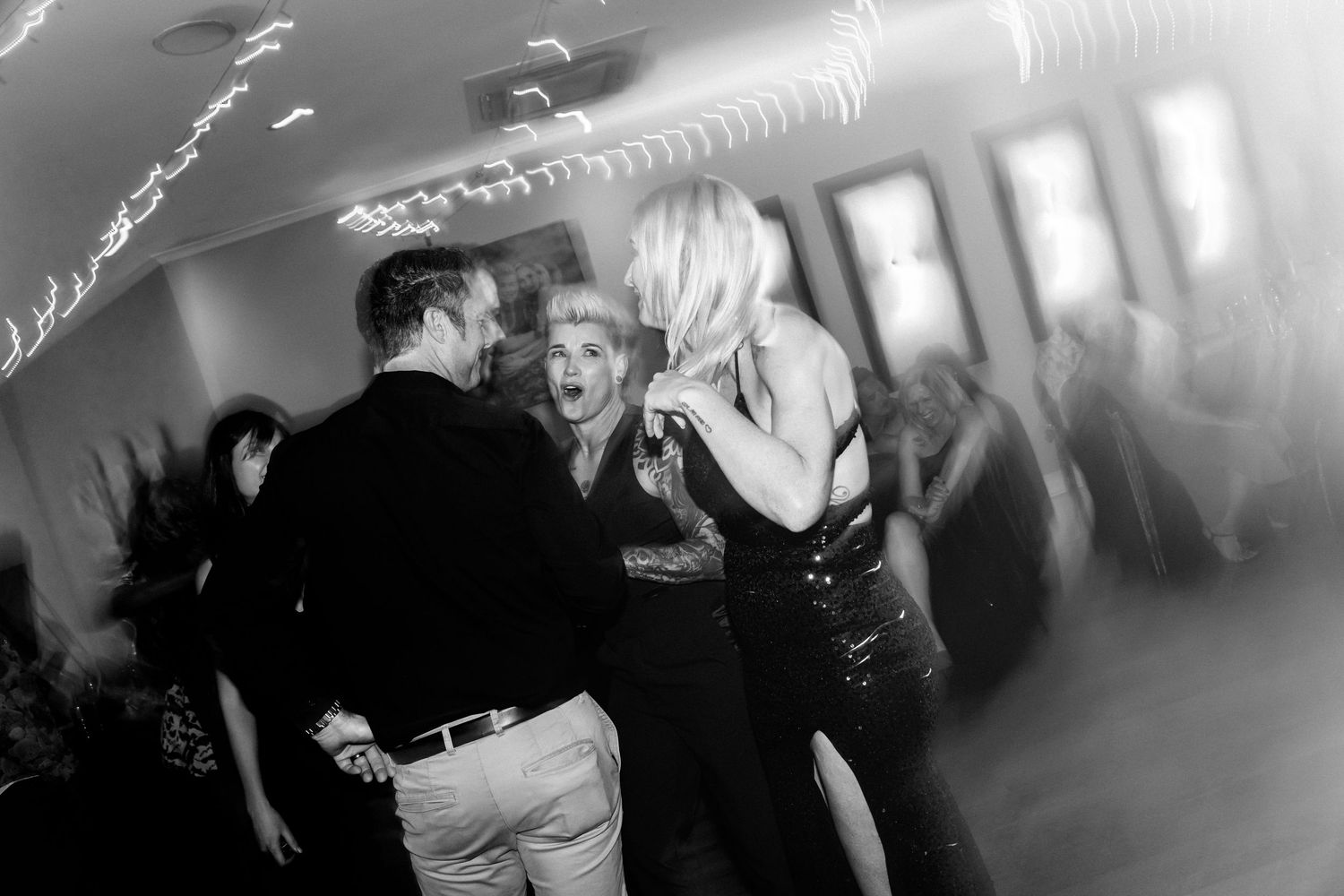 People dancing and having fun at a party in a black and white photograph.