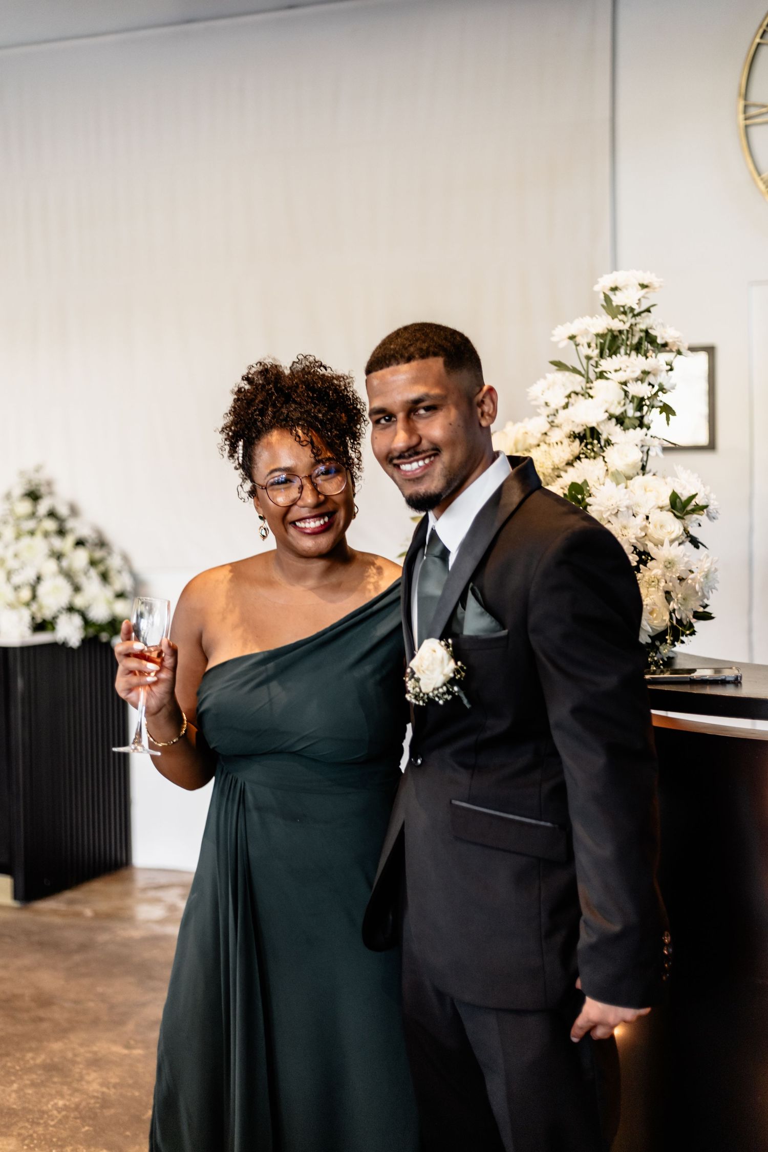 Four sequential photos show a couple in formal attire sharing joyful moments against a simple indoor backdrop.