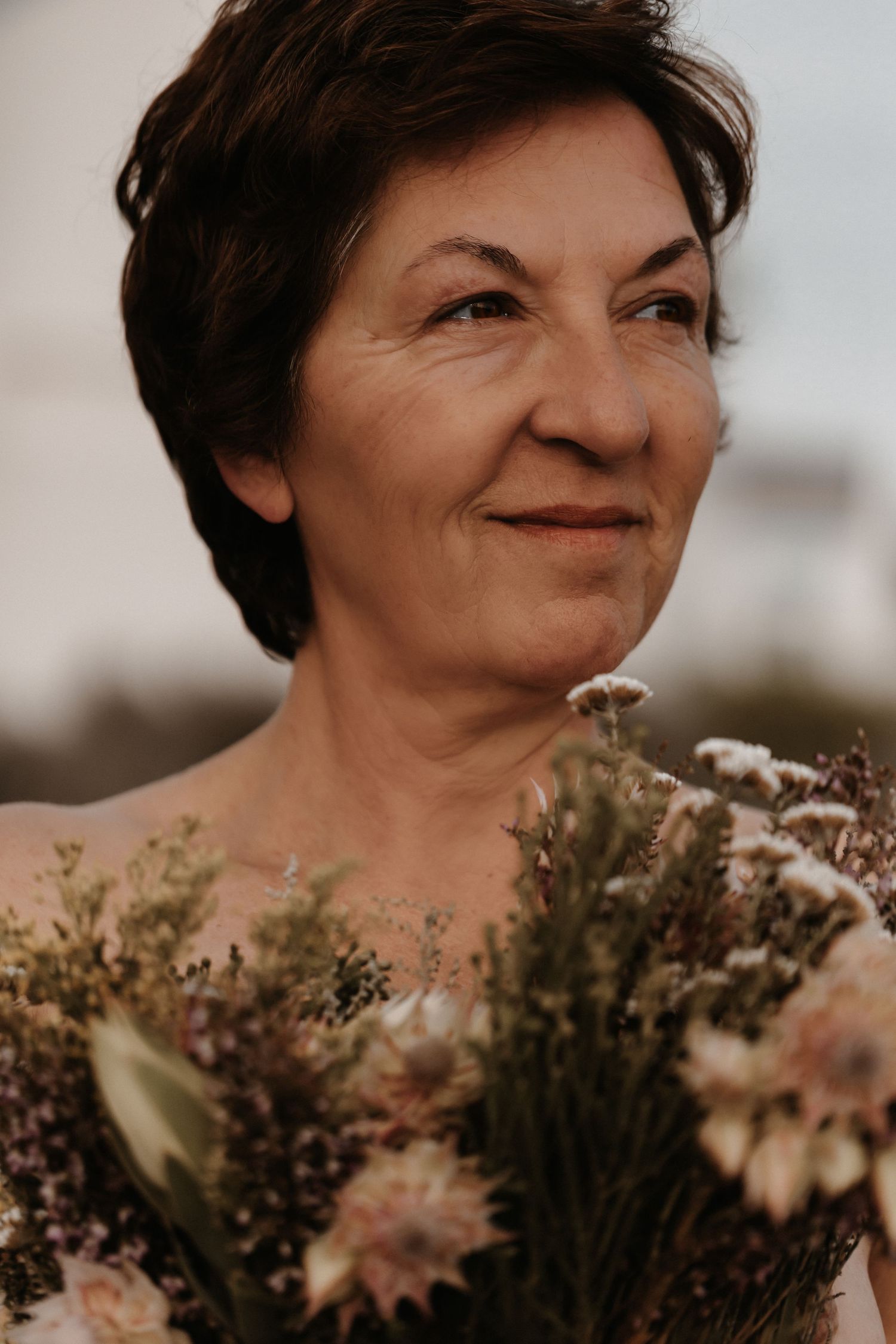 A series of candid close-up portraits showing someone smiling with flowers in warm natural light against a blurred background.