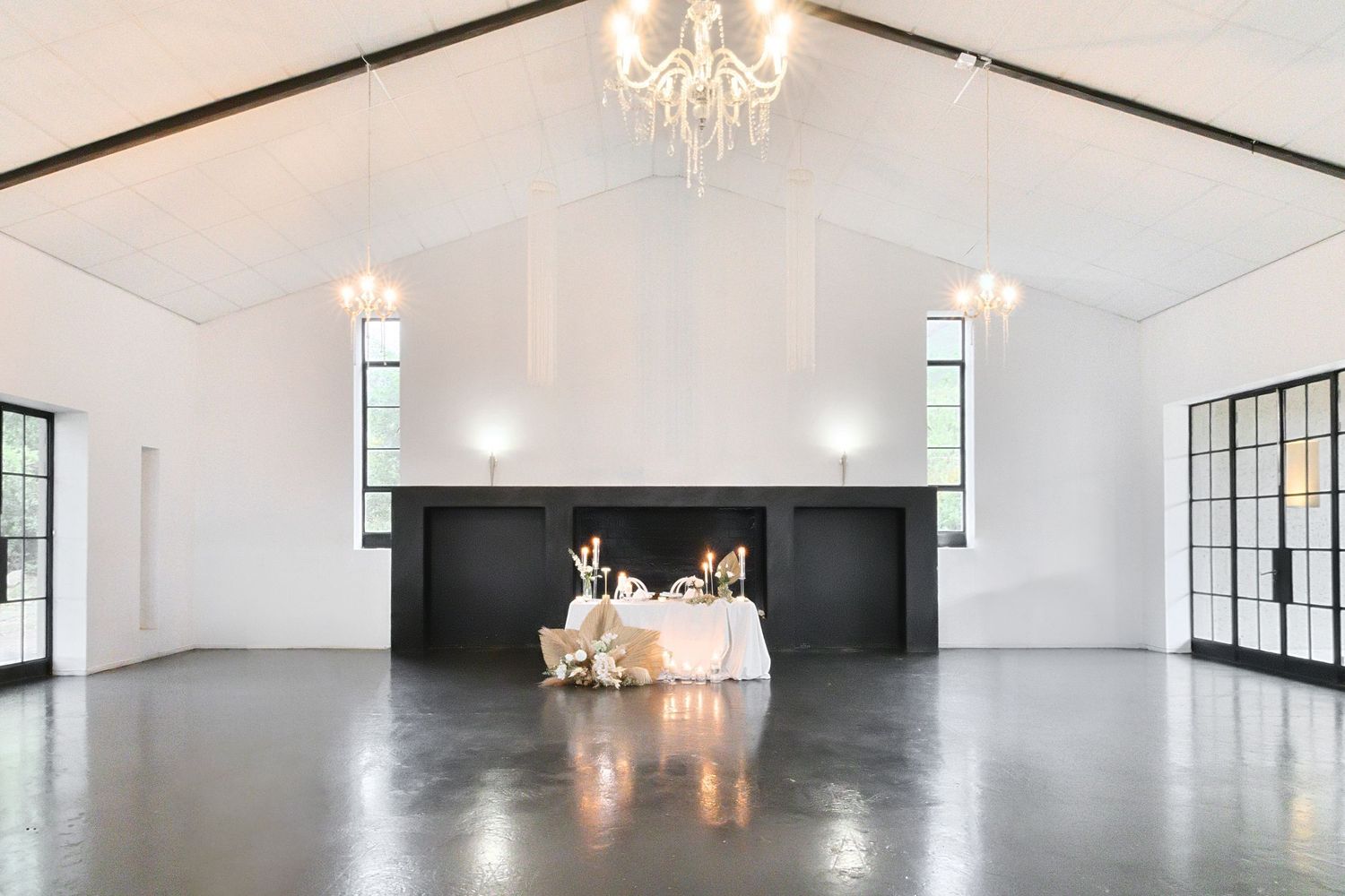 Elegant white event venue with chandeliers, large windows, and polished concrete floors shown from multiple angles.