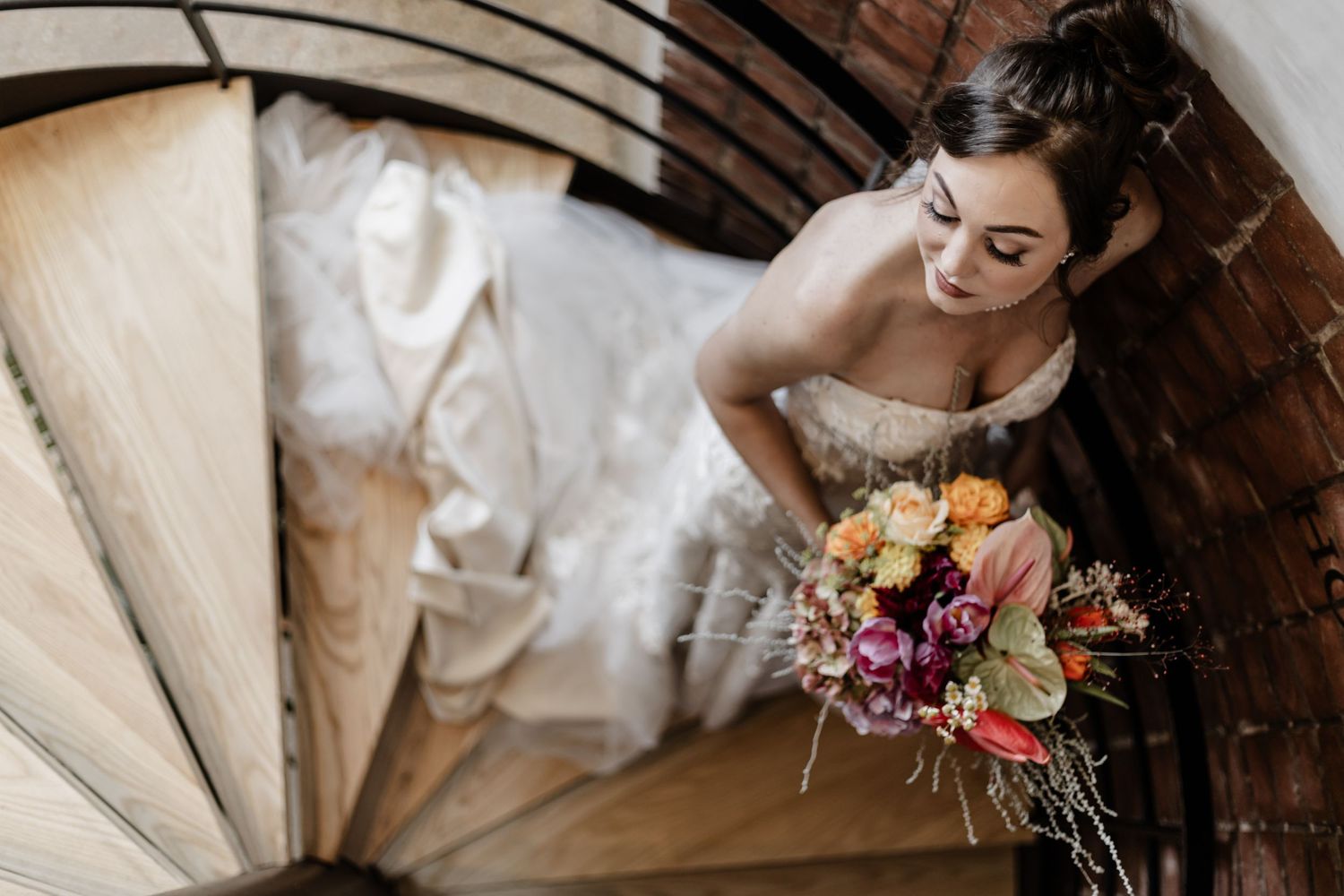 A wedding couple shares a joyful moment during their rustic barn ceremony with floral bouquet details.