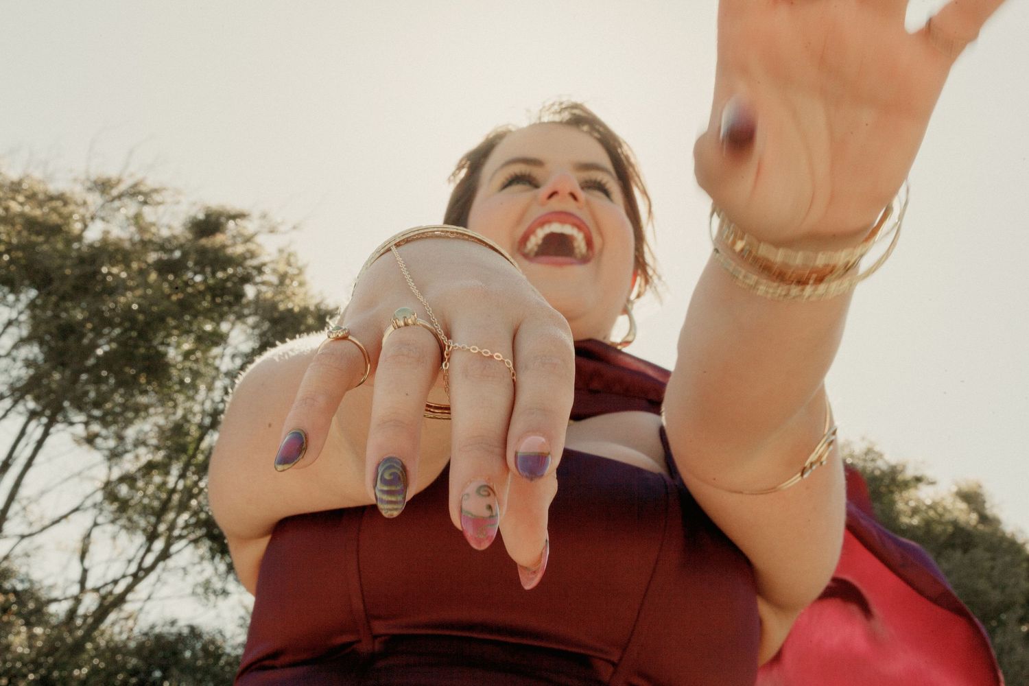 A collage of hands showing off engagement rings in various outdoor settings during sunset.