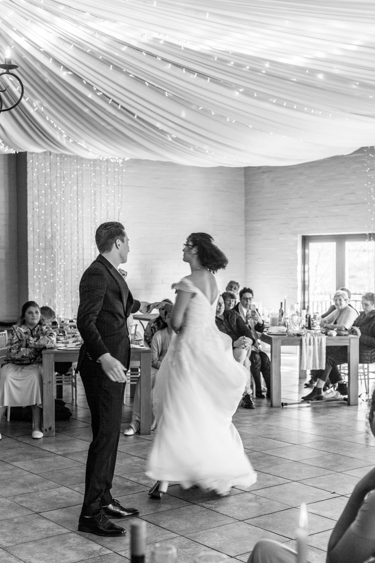 A black and white photo sequence shows a couple's first dance in a reception hall with draped fabric ceiling.