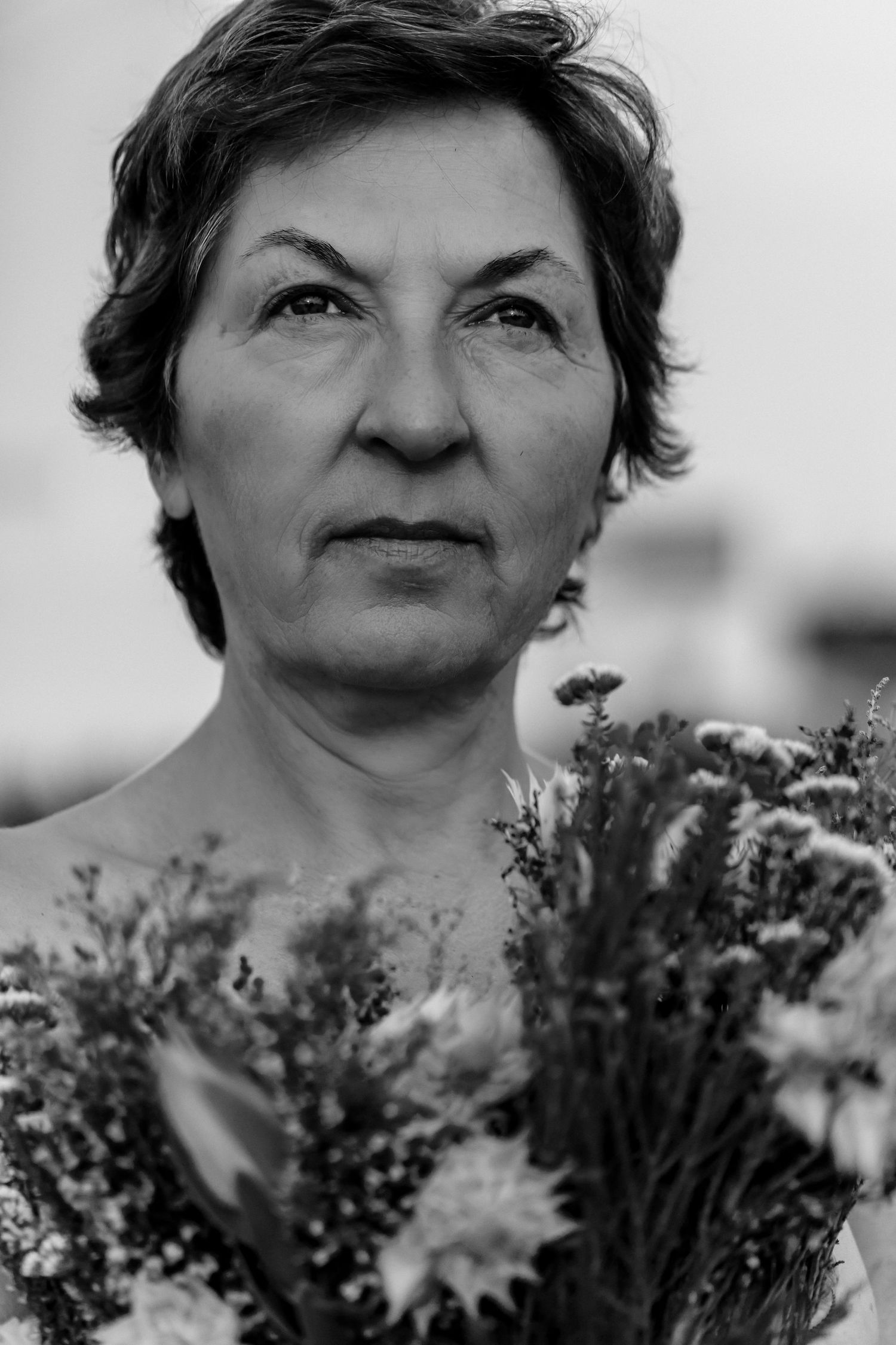A black and white photo montage showing close up views of someone in a garden with blooming flowers.
