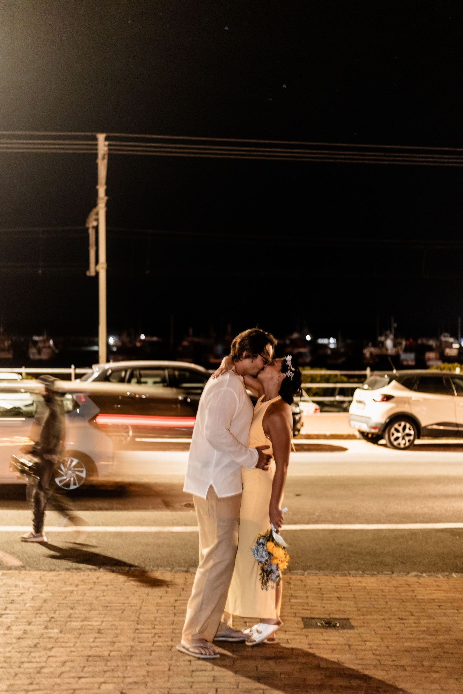 A series of nighttime photographs showing a couple embracing in an illuminated parking lot with cars visible in the background.