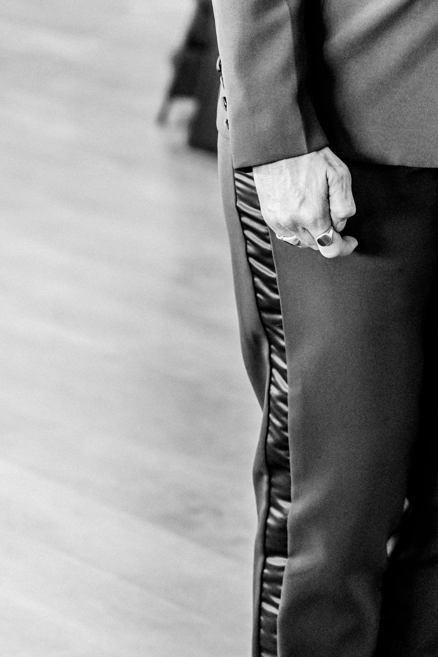 Close-up view of hands gripping a black leather bag handle against a blurred background.