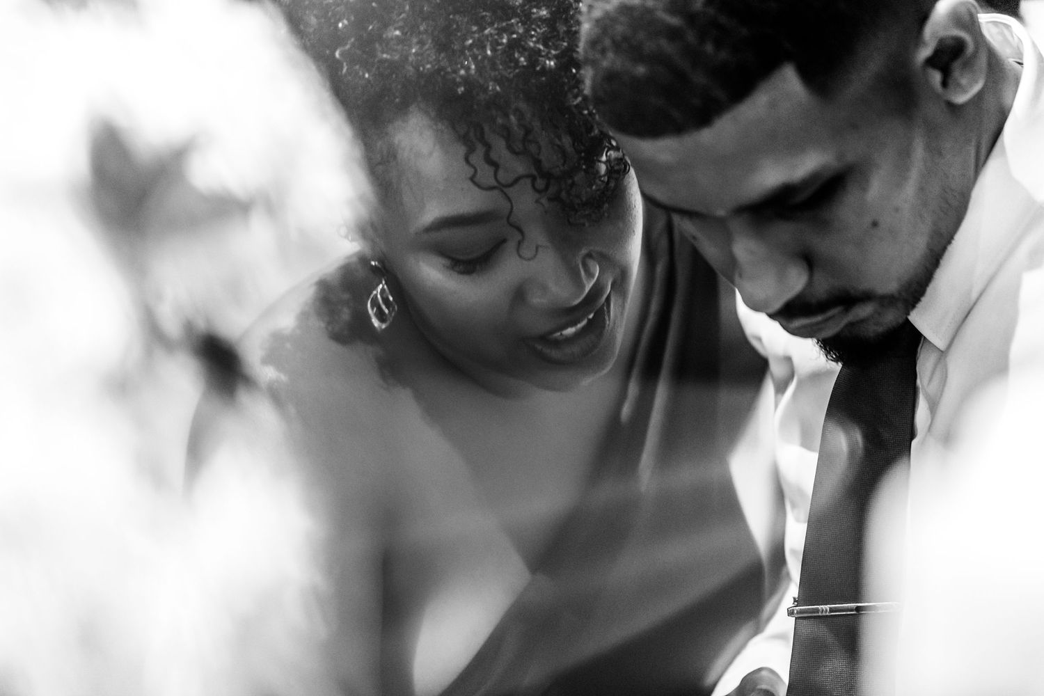 A romantic black and white moment captured between a couple in an intimate pose during a special occasion.