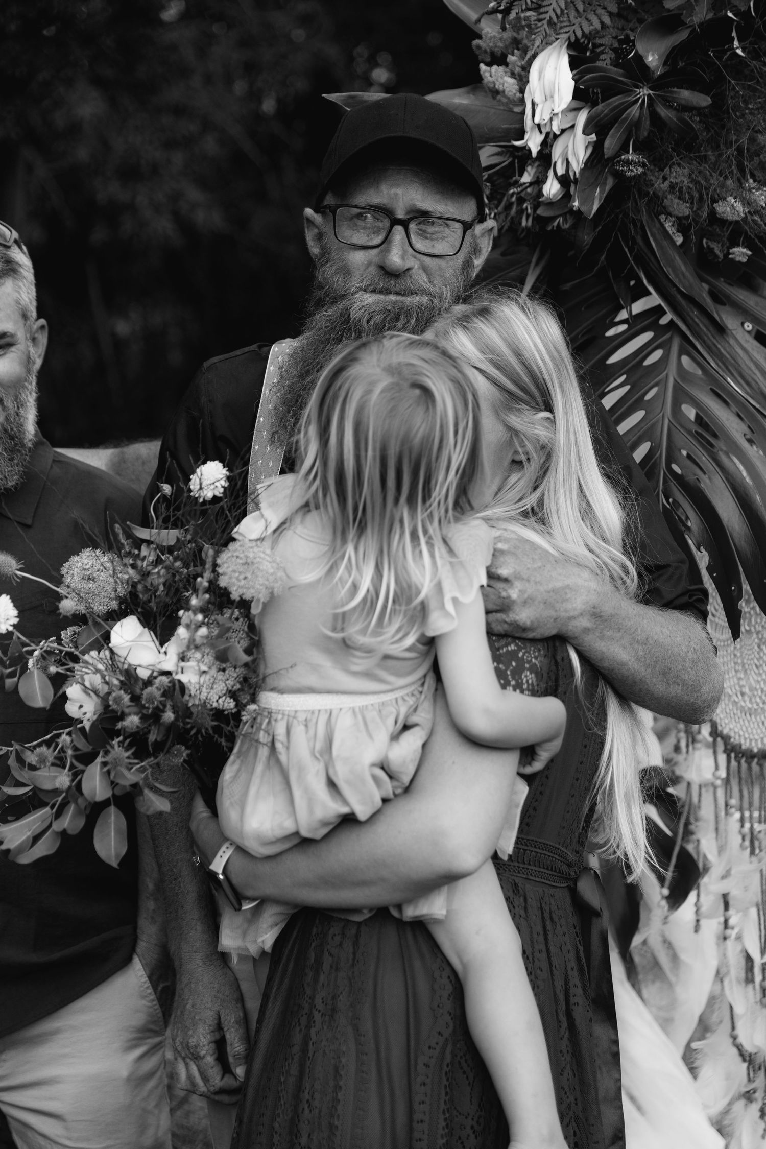 Black and white photo series showing emotional embrace between parent and child at outdoor gathering.