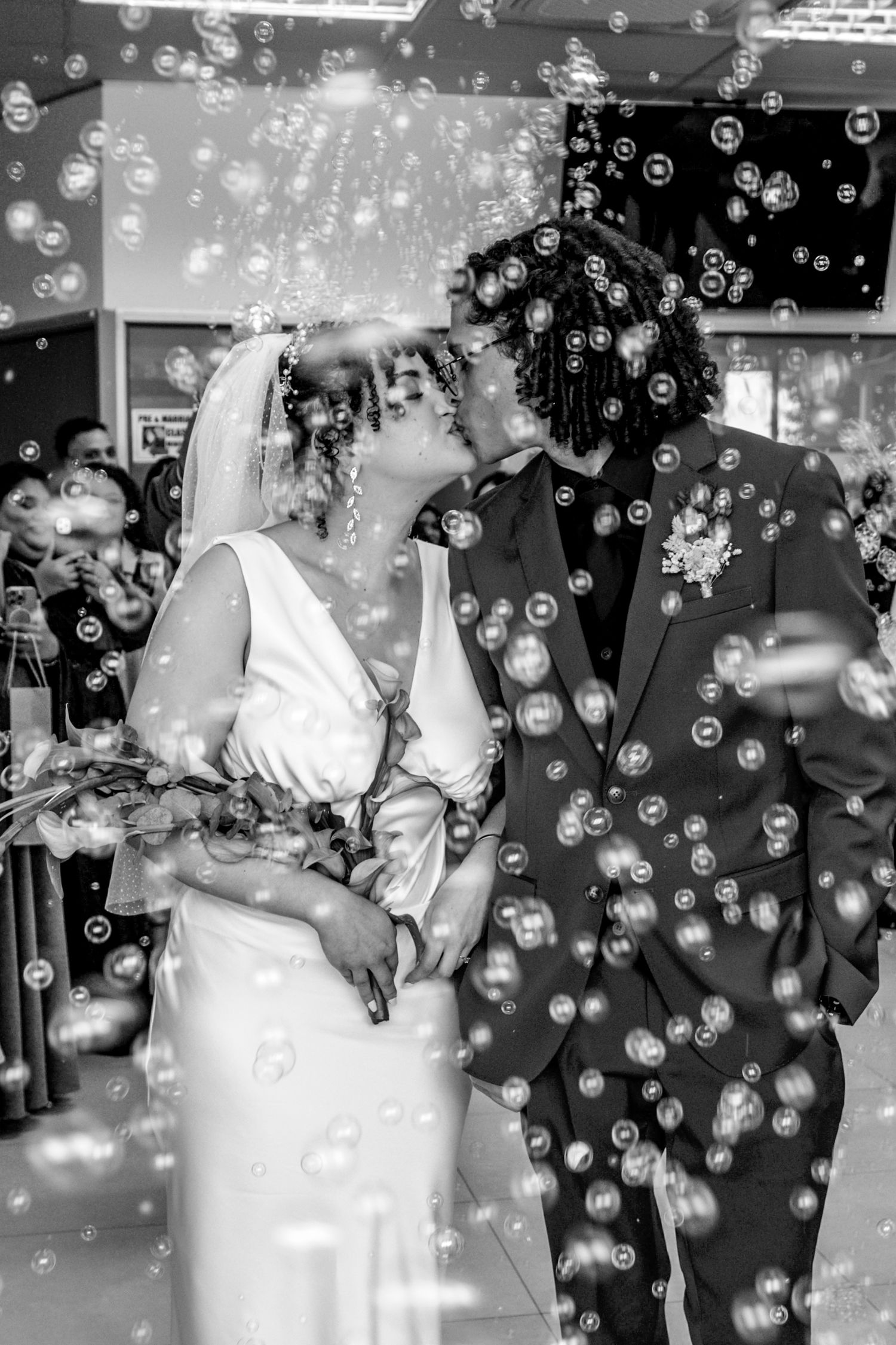A couple enjoys their first dance as newlyweds surrounded by floating bubbles at their wedding reception.