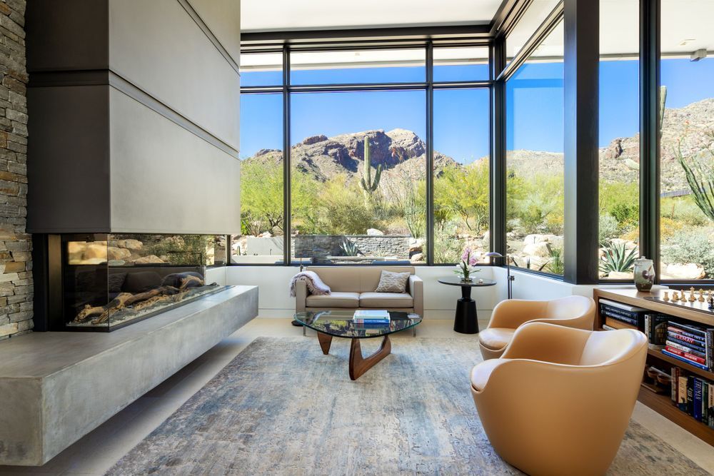 Modern luxury living room with floor-to-ceiling windows offering panoramic mountain views.