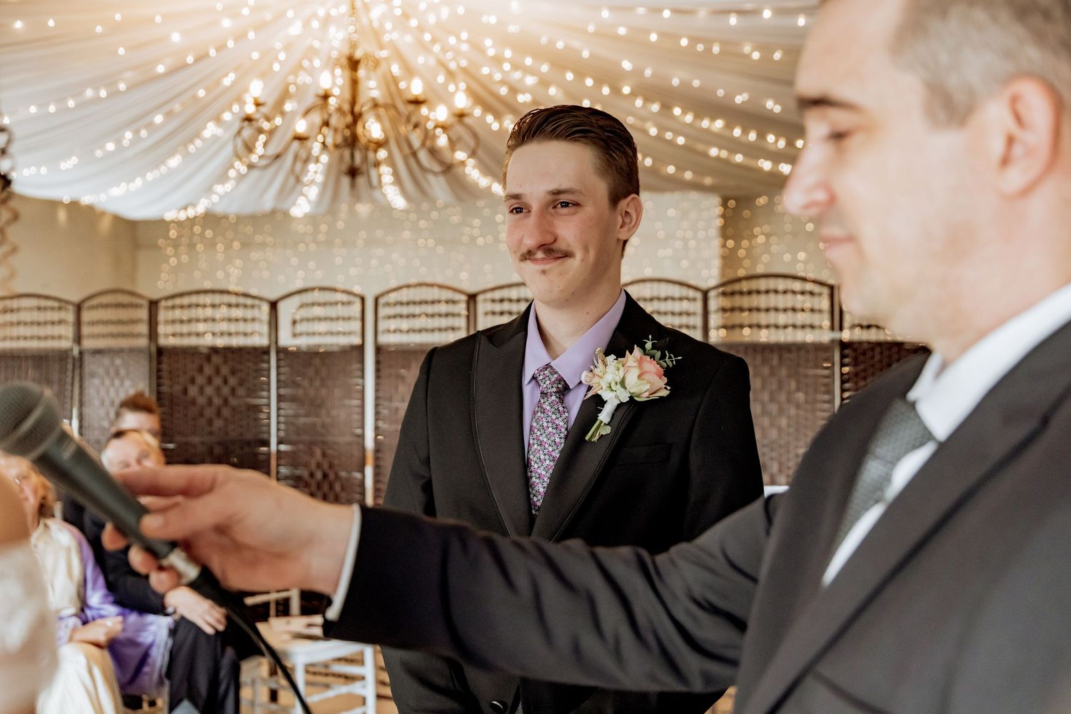 People celebrating and toasting with champagne glasses under a sparkling chandelier at an elegant event.