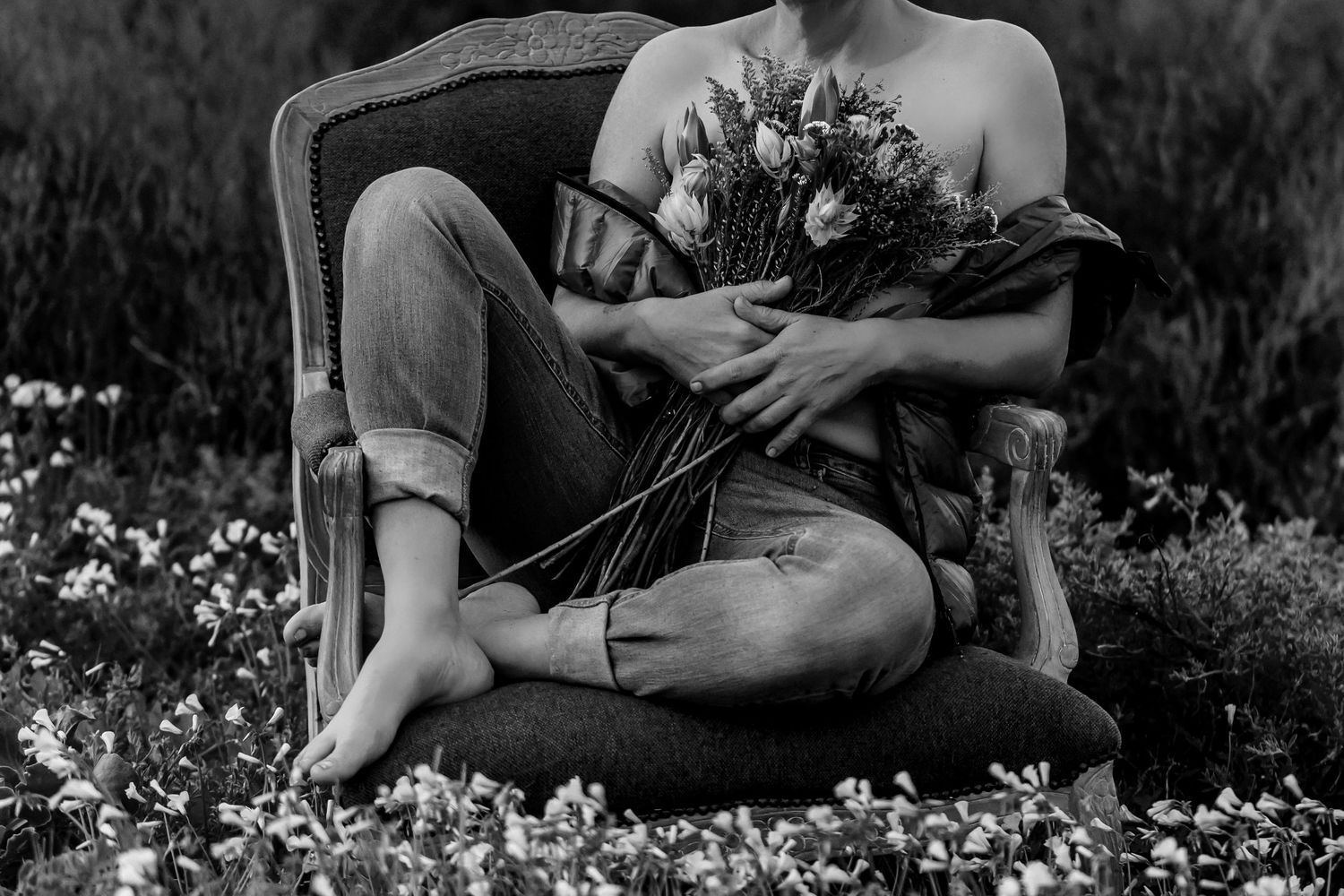 Black and white photo series showing couple sitting in wildflower field holding bouquet during engagement session.