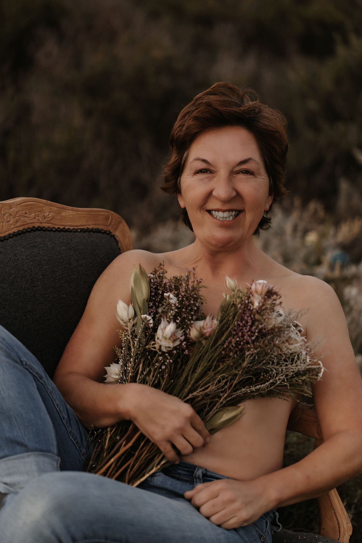 A boudoir photoshoot series featuring intimate poses with a rustic floral bouquet against a dark background.