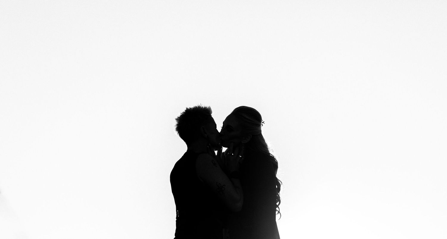 A row of silhouettes of people standing against a white background.