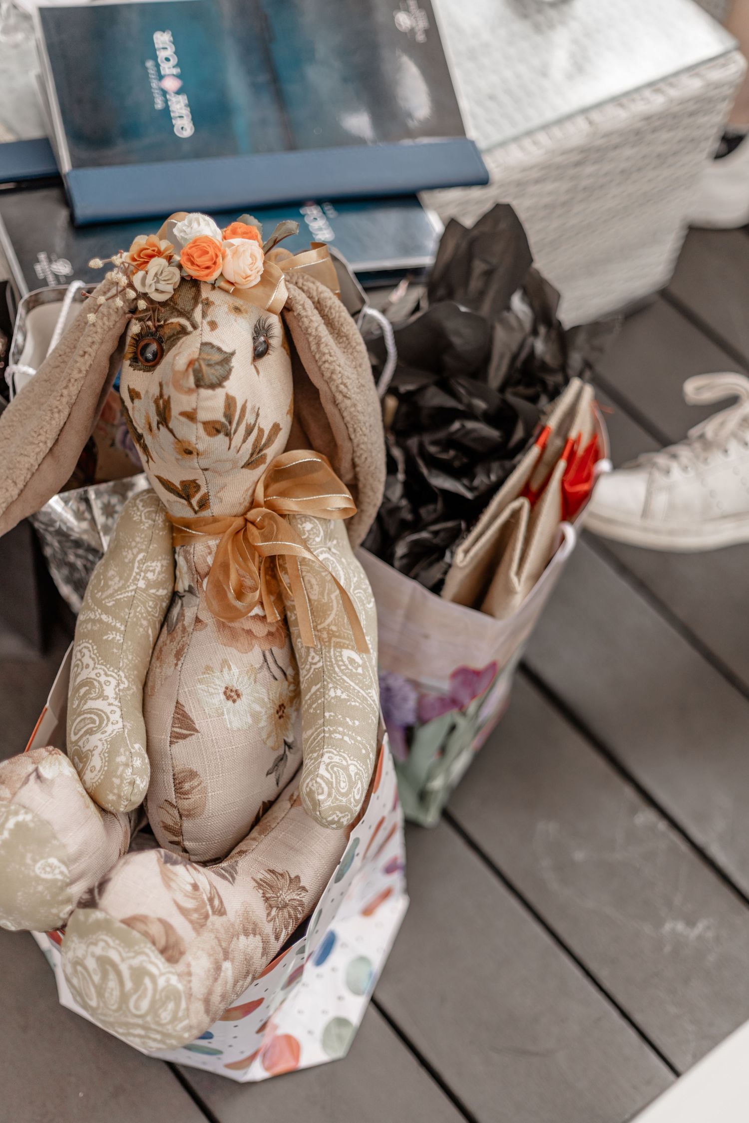 A decorative plush rabbit with floral patterns and orange bow sits among personal belongings.