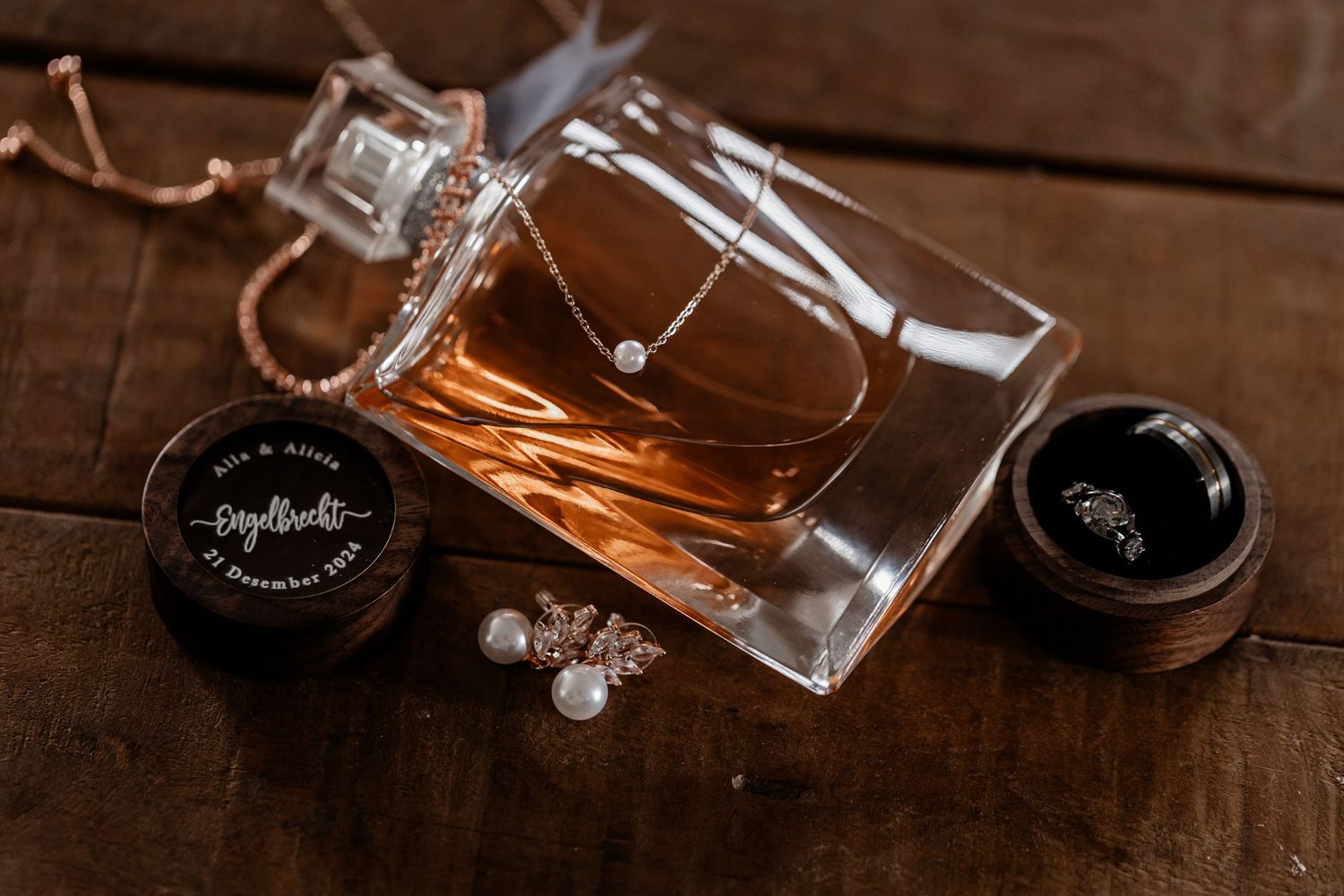 Crystal wine glass laying on its side with amber liquid spilling out onto dark wooden surface in dramatic lighting.