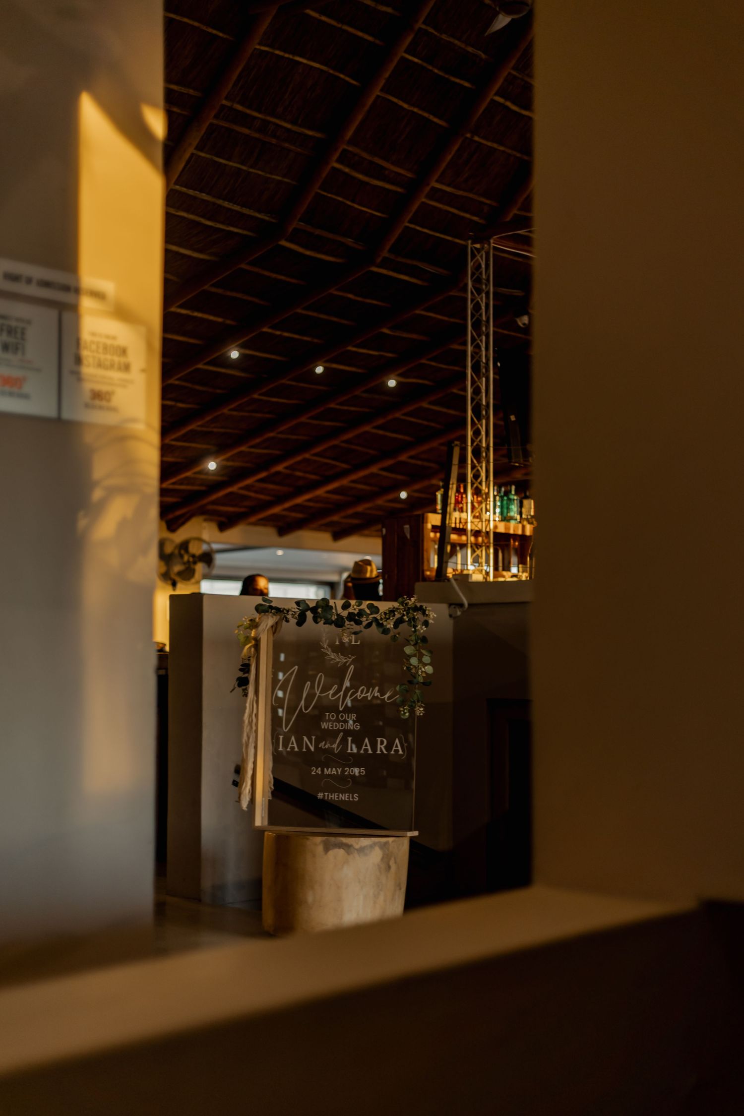 Interior view of a dimly lit cafe with exposed ceiling beams and warm ambient lighting creating a cozy atmosphere.