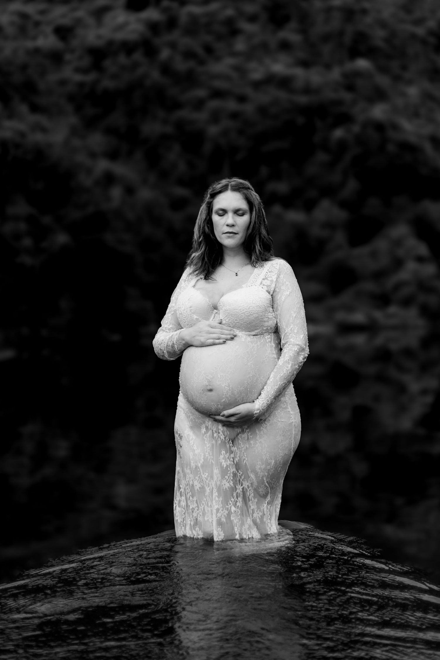A series of moody black and white photos showing someone in a white lace dress standing in dark water creating a dramatic effect.