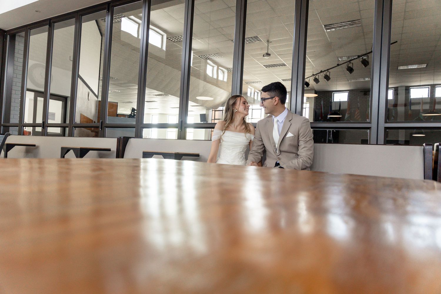 Modern office interior with long empty hallway, white walls, and large windows providing natural light.