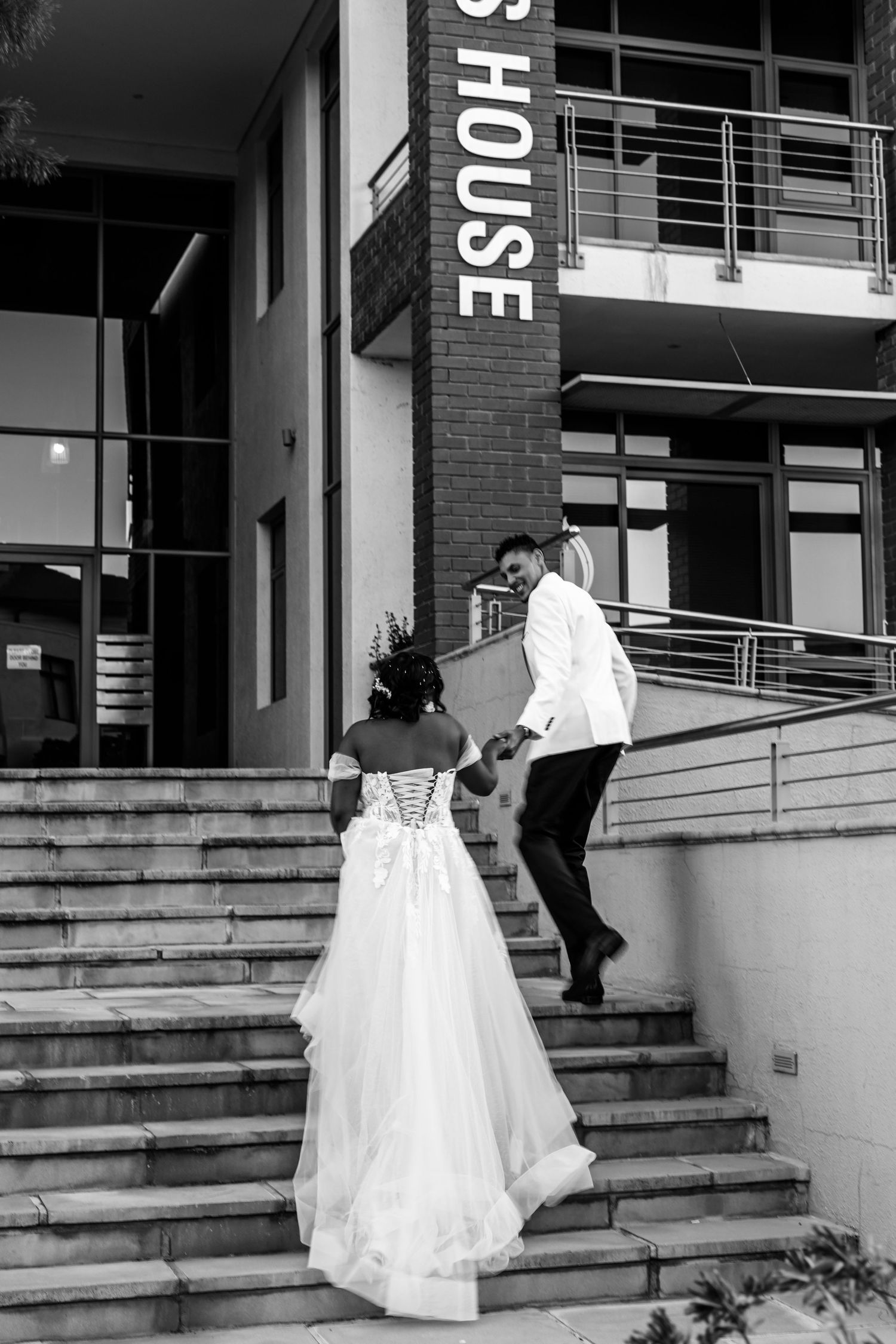 Multiple views of a bride climbing stairs in flowing white gown at a modern brick building entrance.