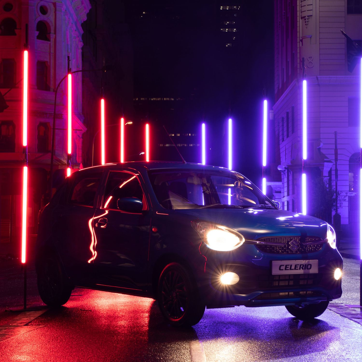 Modern vehicle captured in urban setting with vibrant red and blue LED light installations.