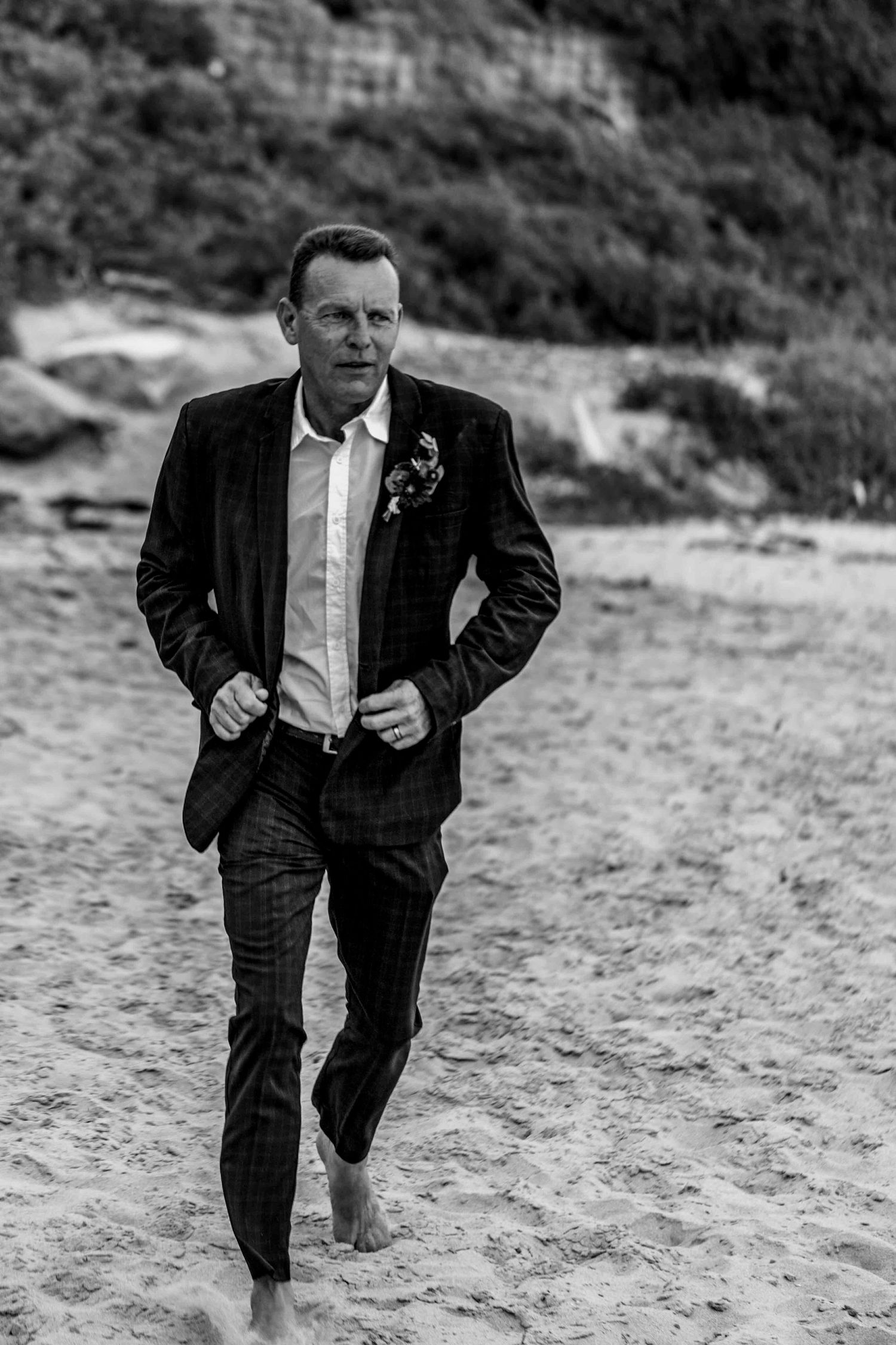 A sequence of black and white photos showing a figure in a suit walking up sandy terrain.