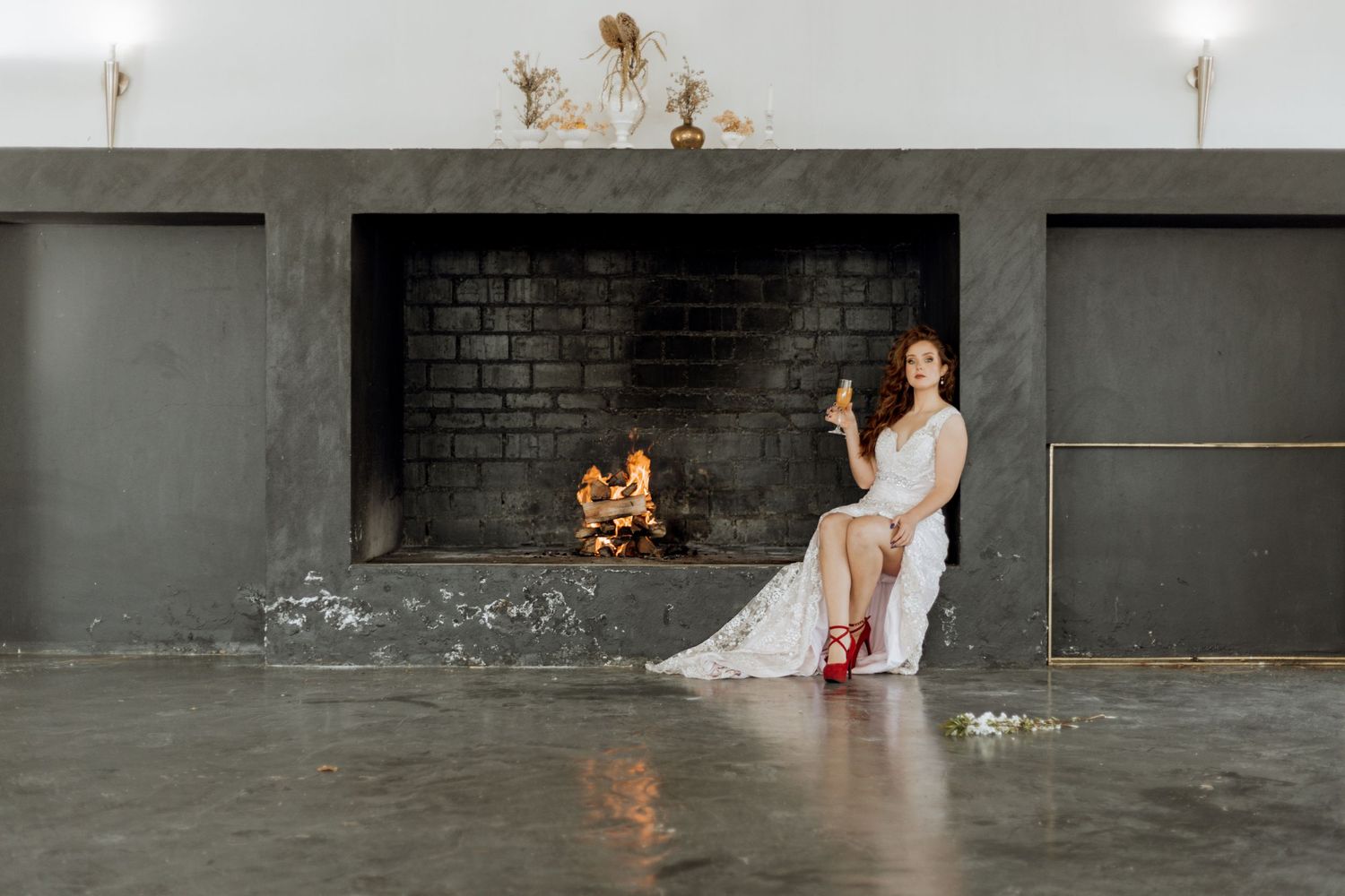 A graceful figure in a white gown and red heels strikes stunning poses on a polished concrete floor.