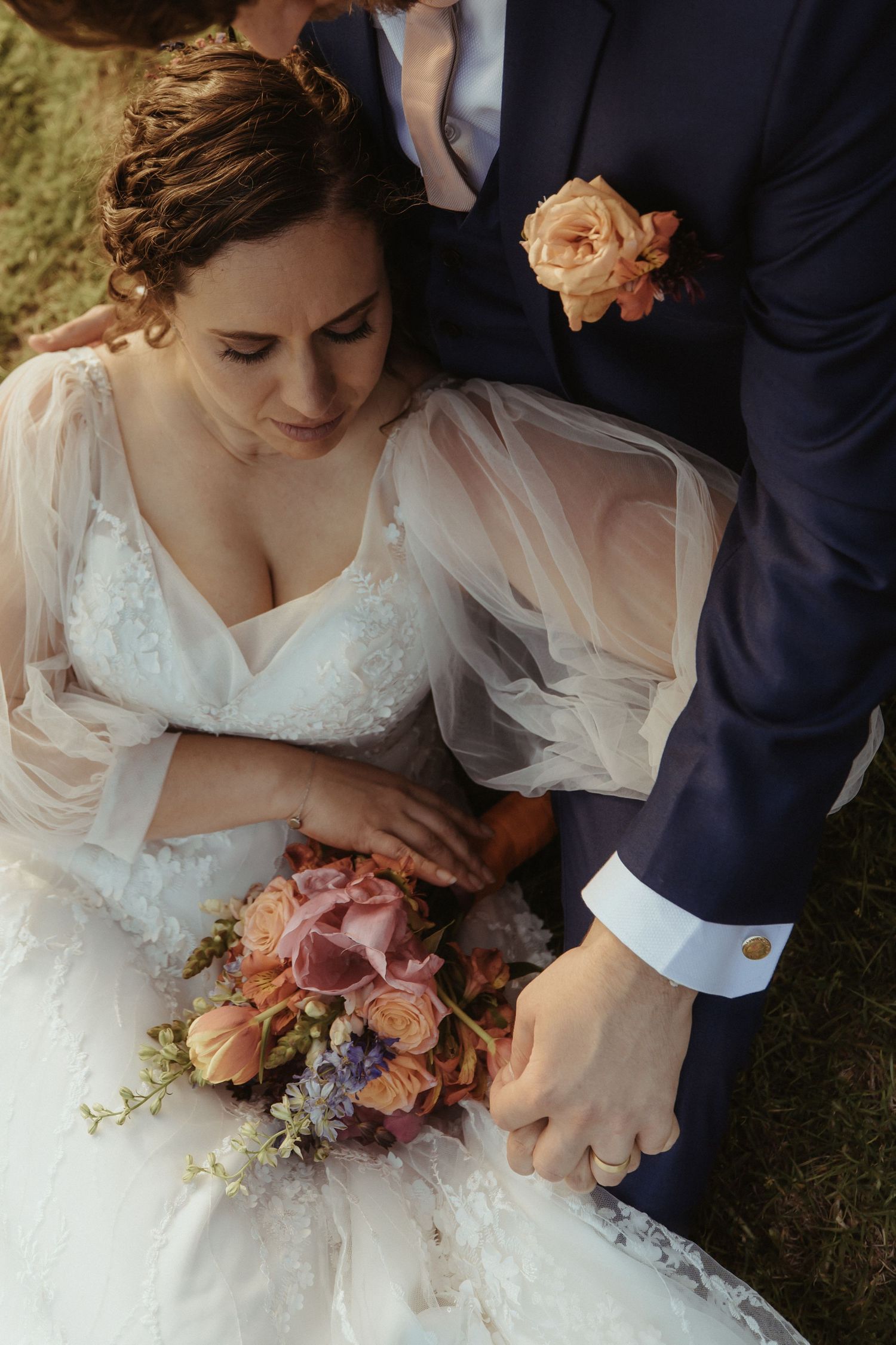Close-up series of a bride in a white lace dress holding a romantic bouquet with pink and purple flowers.