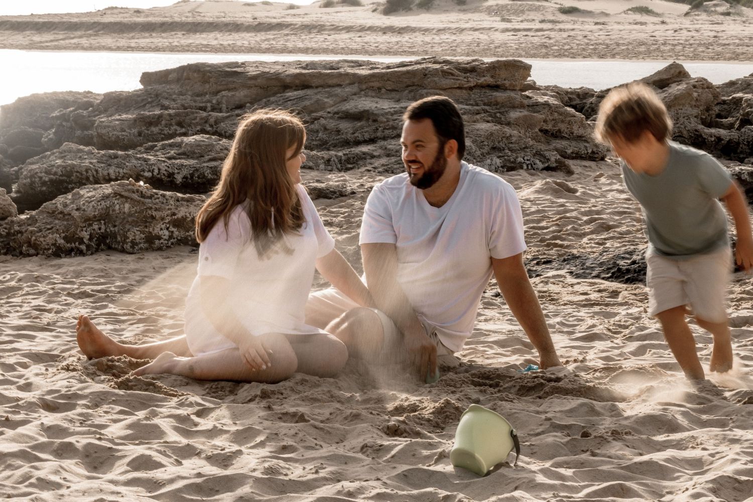 People relaxing on a sandy beach during a sunny day while enjoying each other's company.