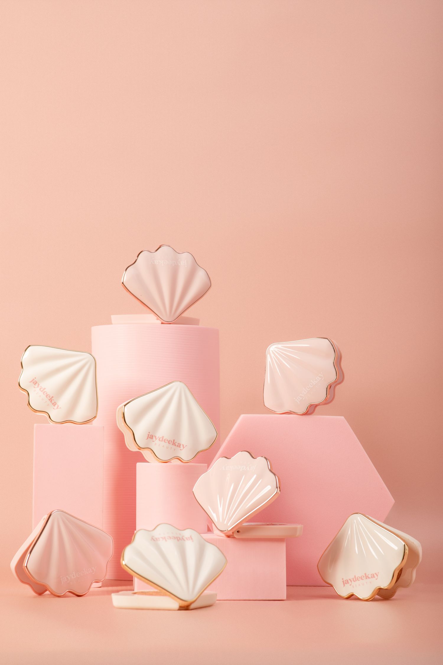 Delicate white meringue cookies arranged with pink geometric shapes against a soft pink background.