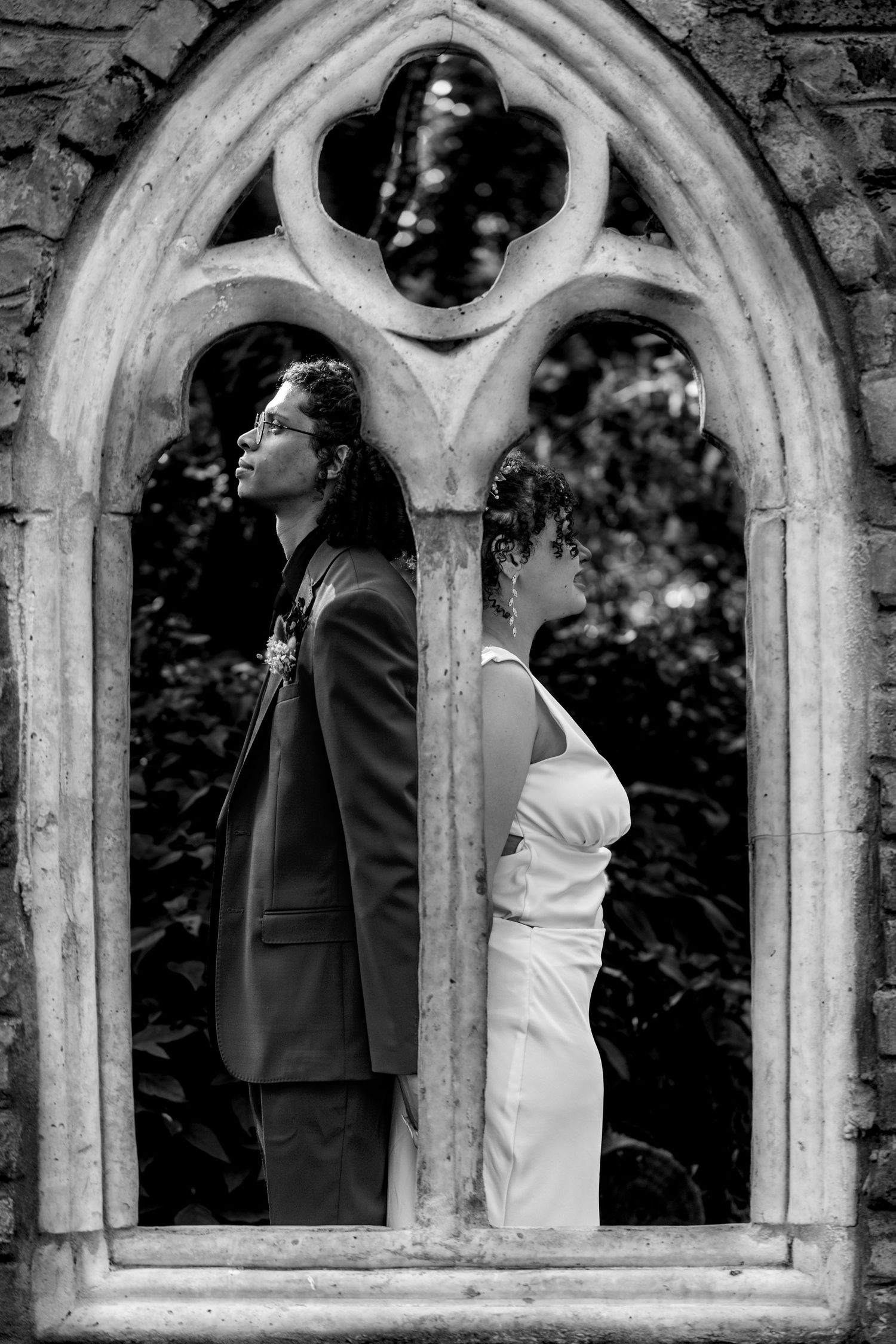 Black and white series of stone church windows showing silhouettes of a couple in romantic poses.