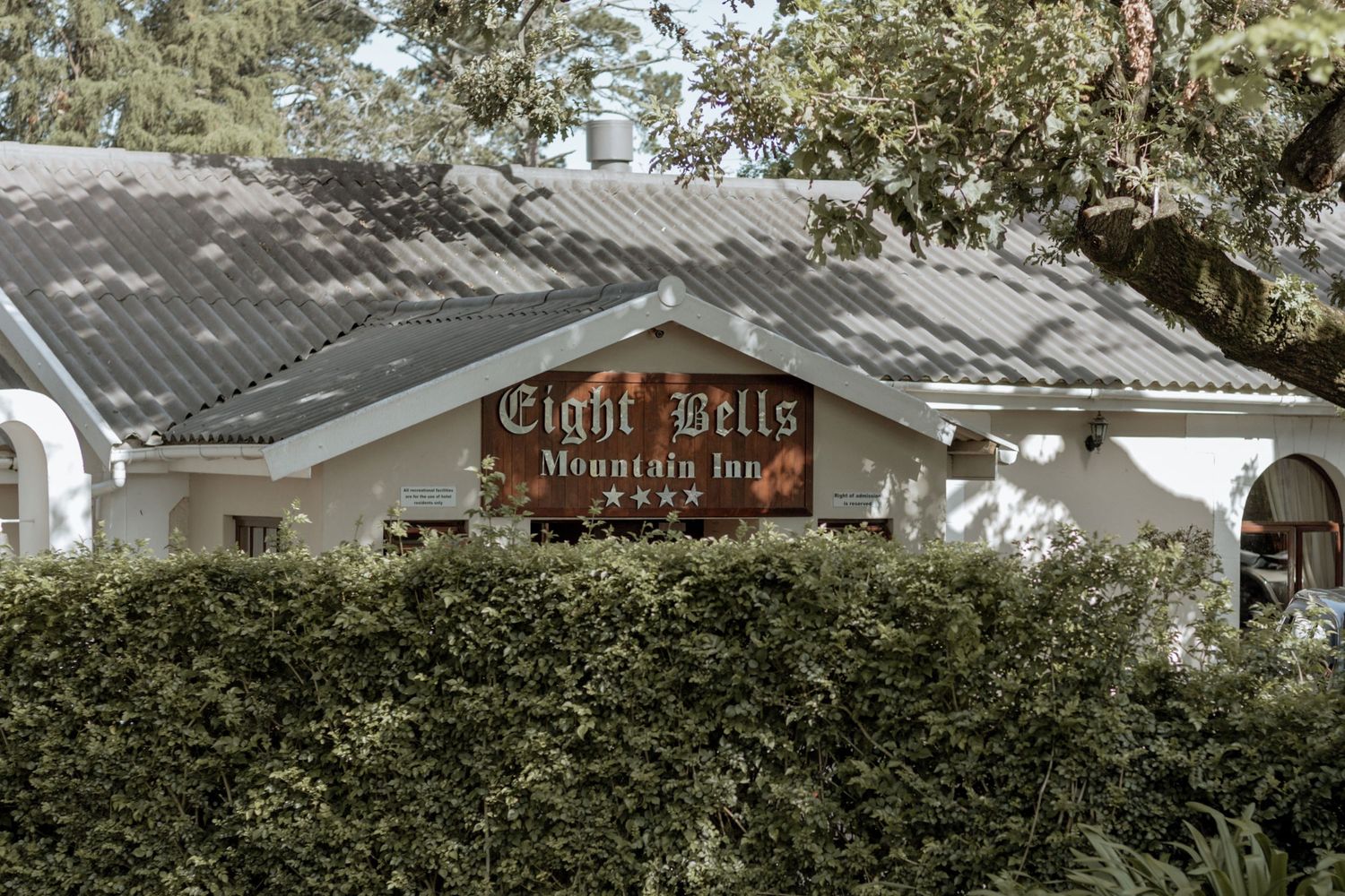 White stucco mortgage bank building with 'Eight Hills' signage and landscaped hedges under a dark tiled roof.
